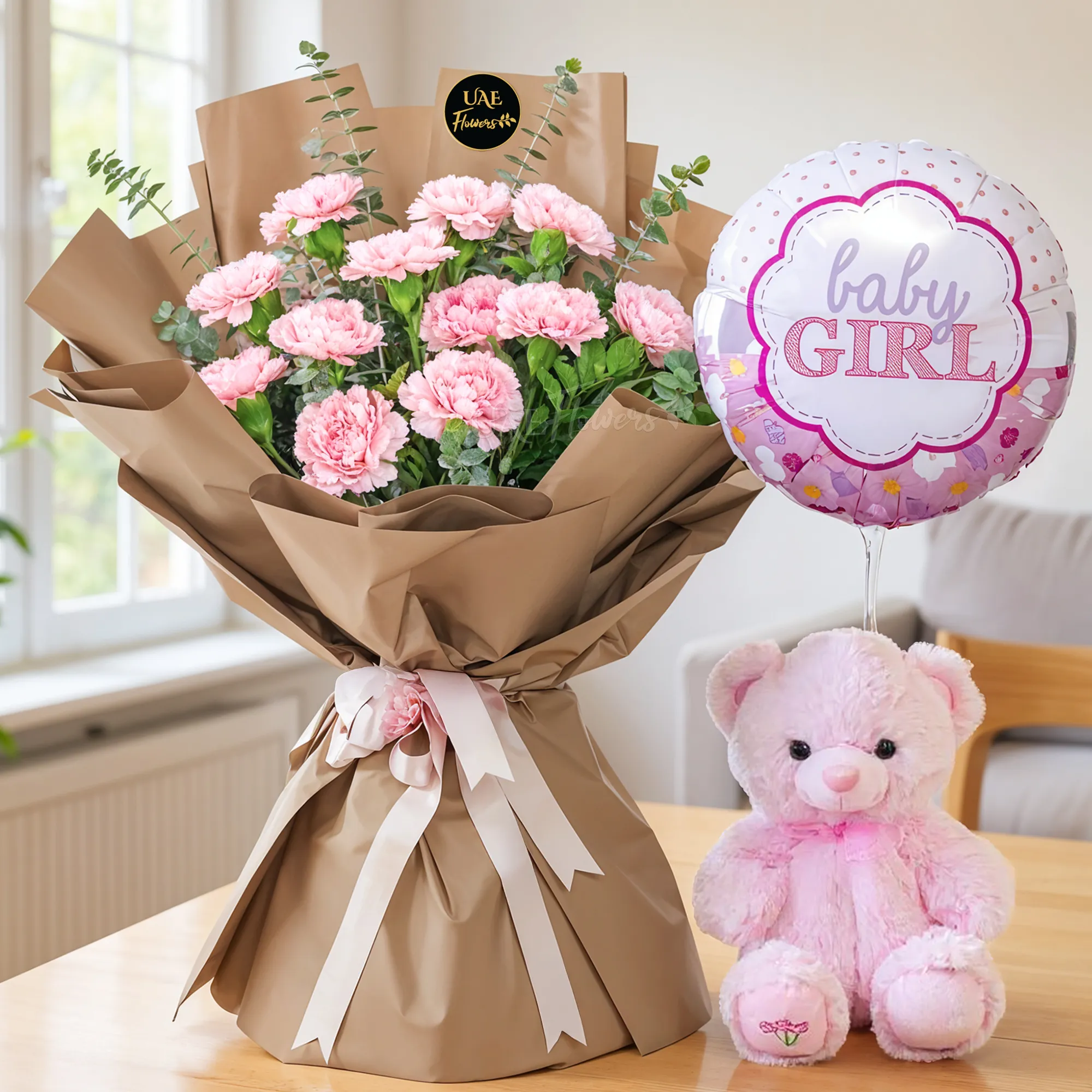 Bouquet of 12 pink carnations with limonium & green fillers in paper packing tied with ribbons, small pink teddy bear and BABY GIRL foil balloon.