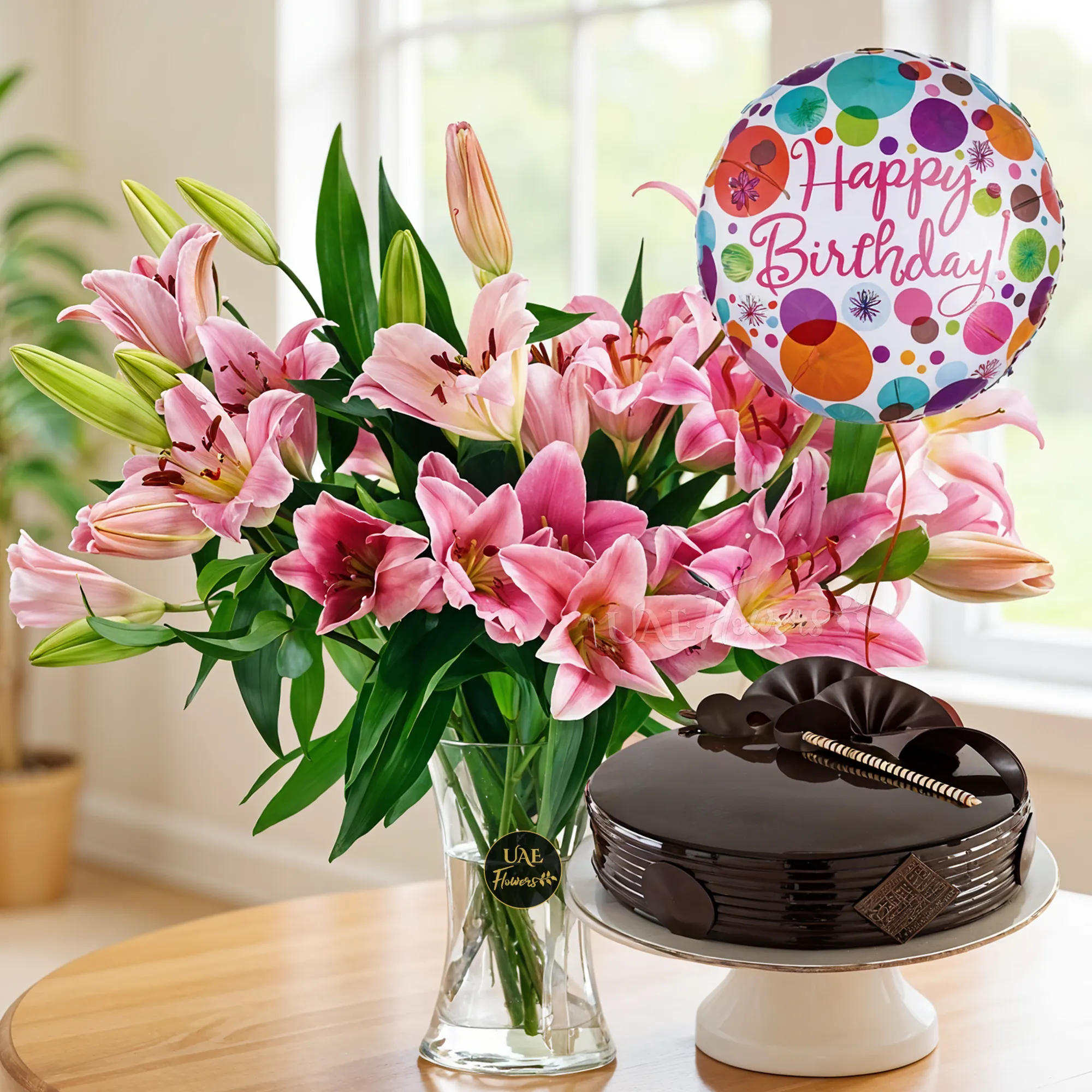 10 Pink Lilies with fillers in a glass vase and 1 Kg Chocolate Cake and Happy Birthday Foil Balloon