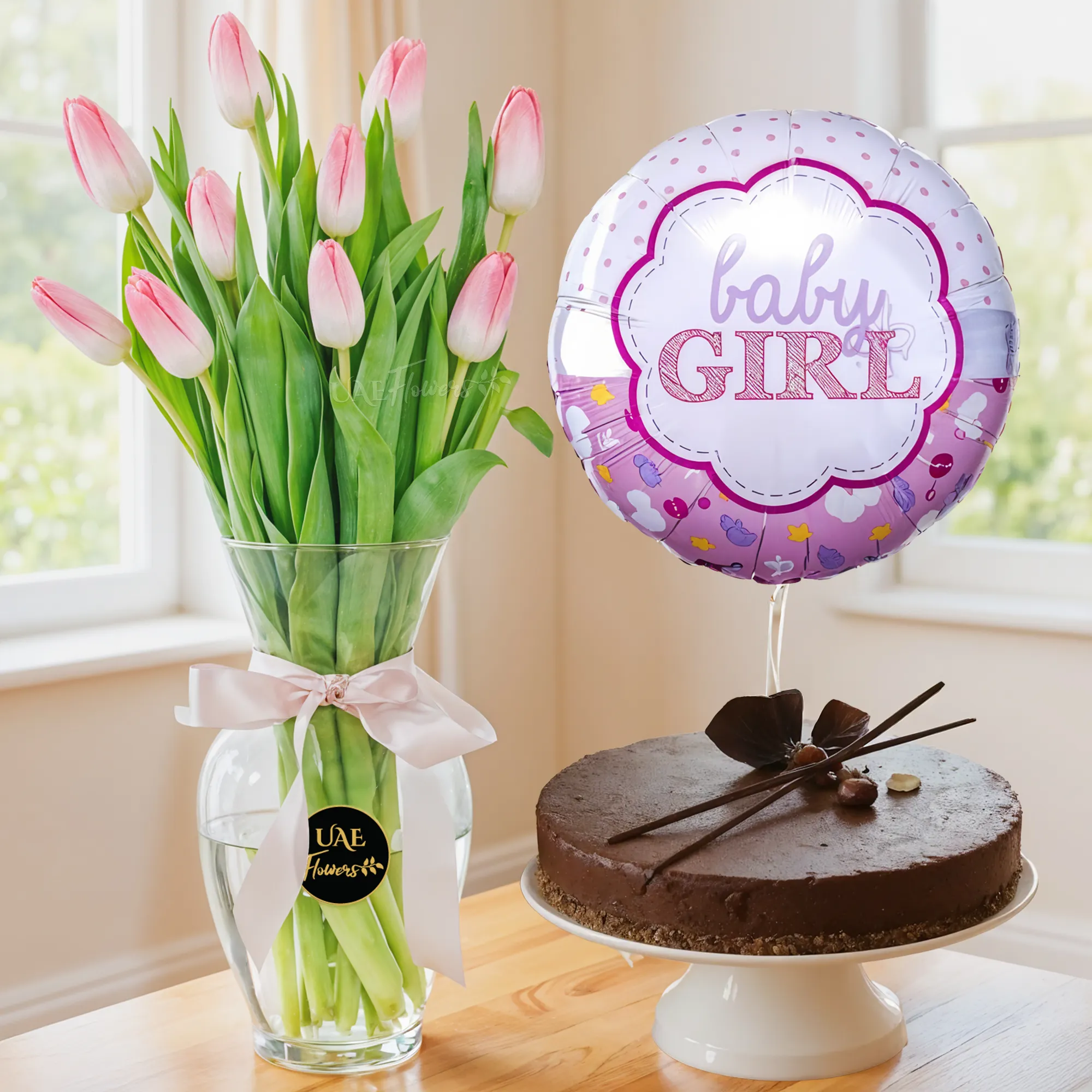 10 pink tulips in a vase, 1 kg chocolate cake and BABY GIRL foil balloon.
