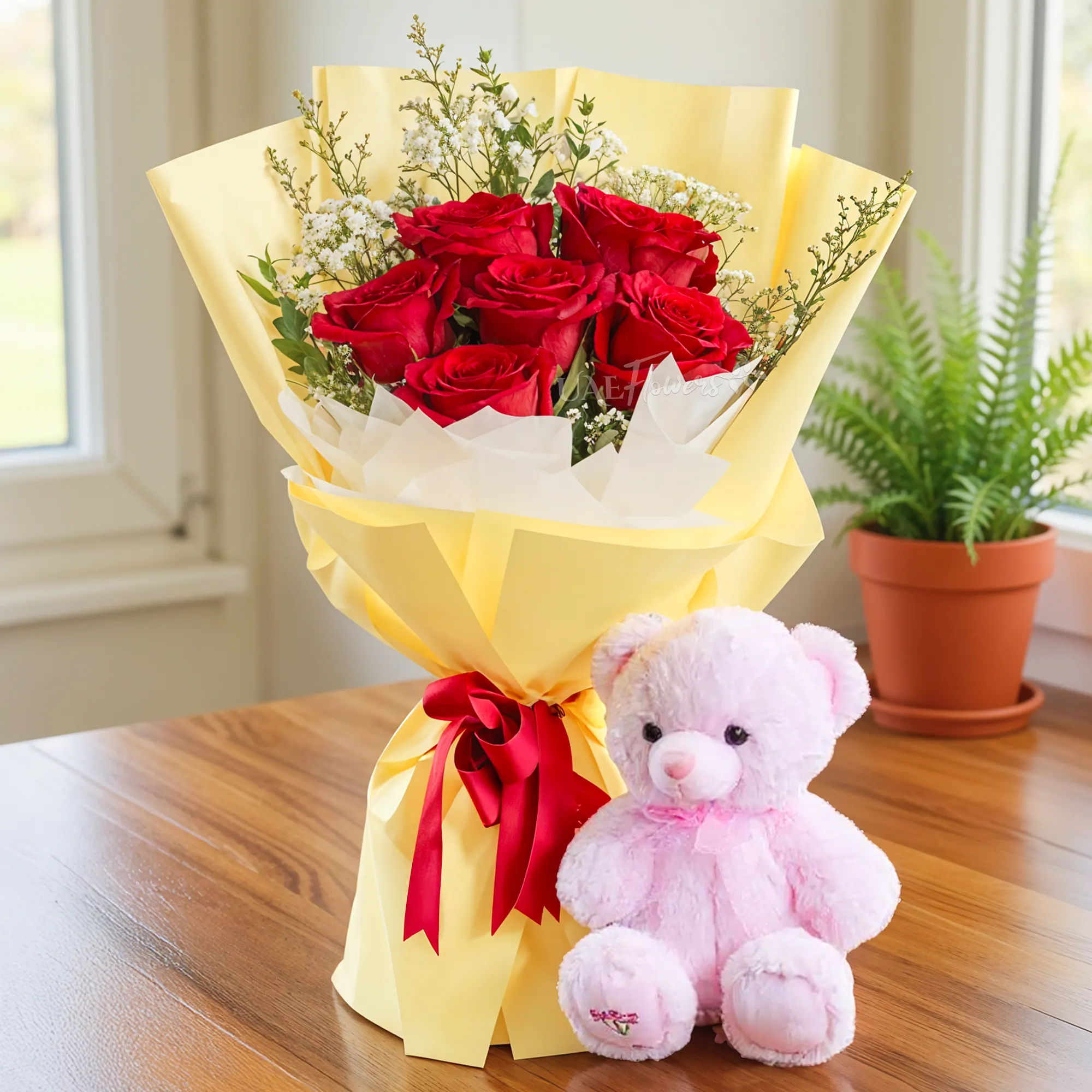 Bouquet of 6 red roses with green fillers in nice wrapping and a small pink teddy bear.