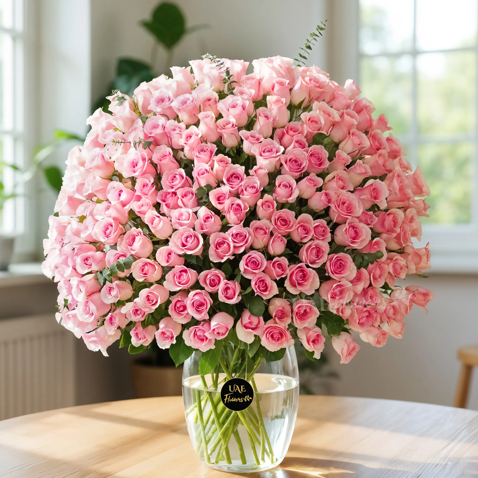 A vase with 200 pink roses with green fillers.