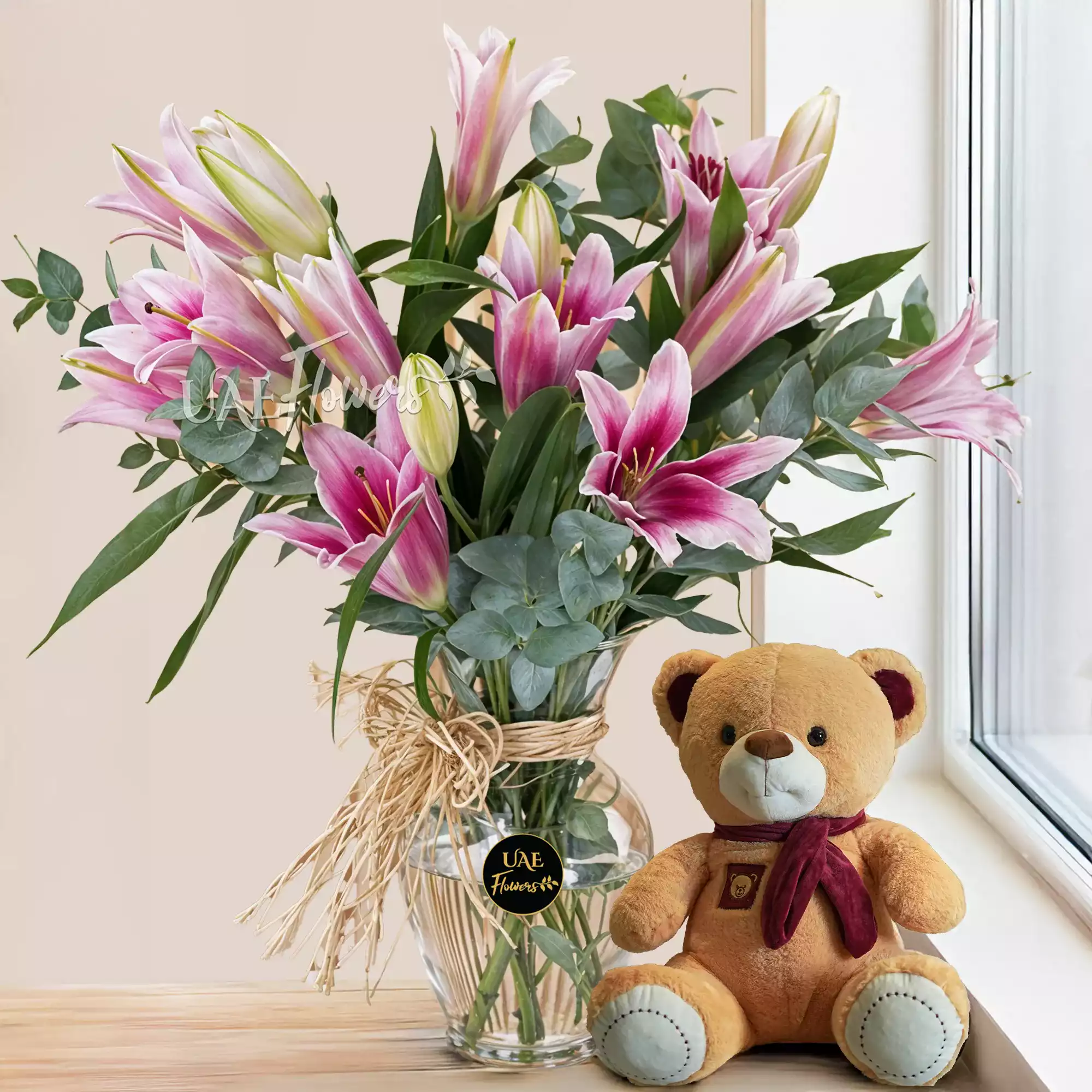 A vase of 5 pink lilies with a small teddy bear