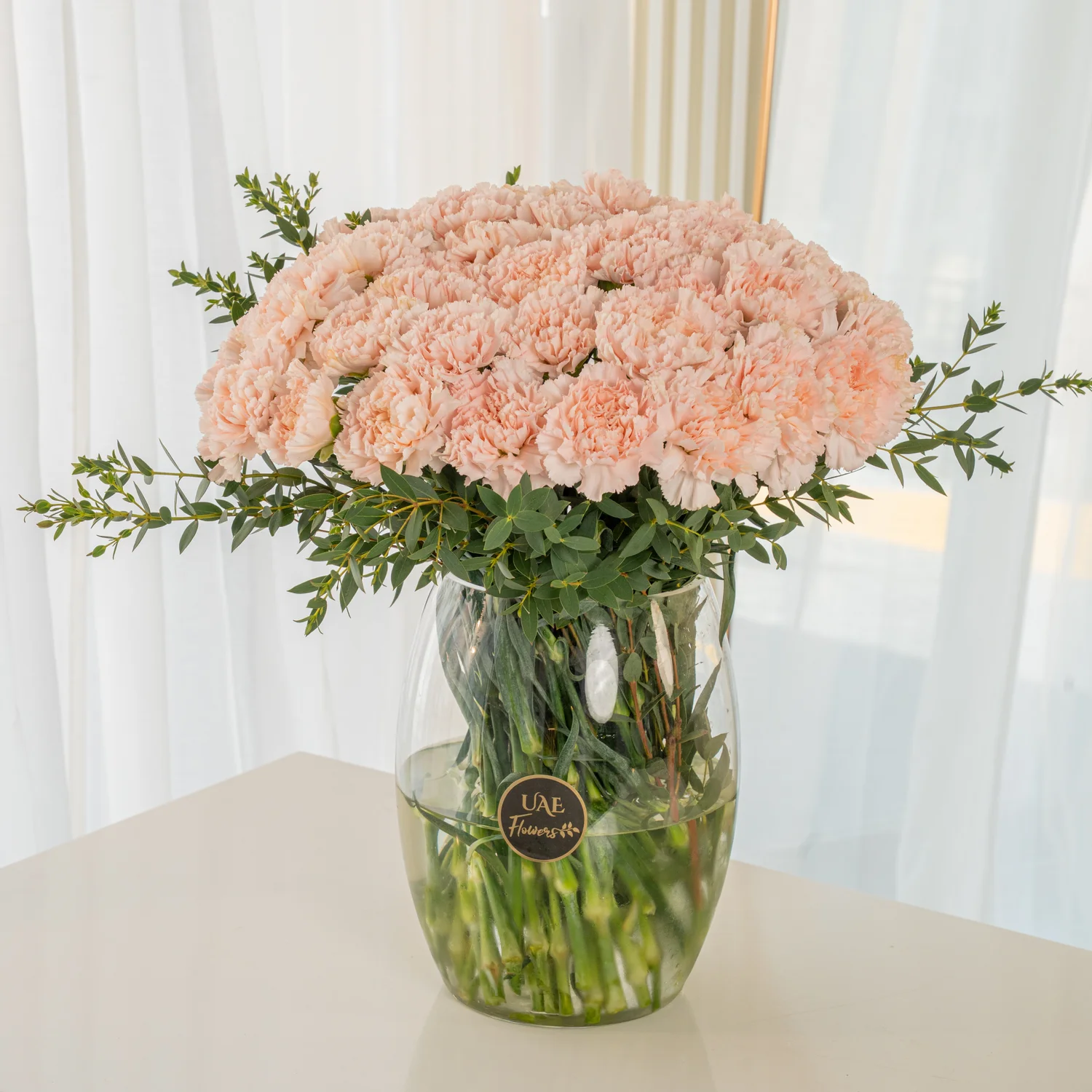 Glass vase of 40 Pink carnations with fillers