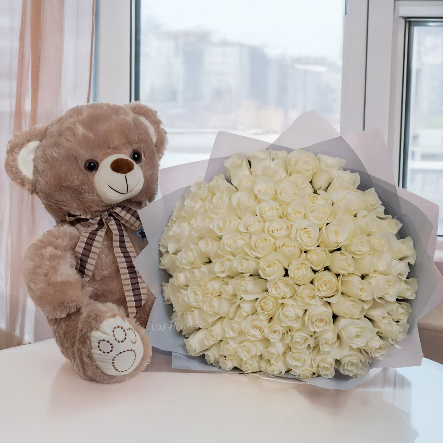 Bouquet of 100 white roses with small brown teddy bear