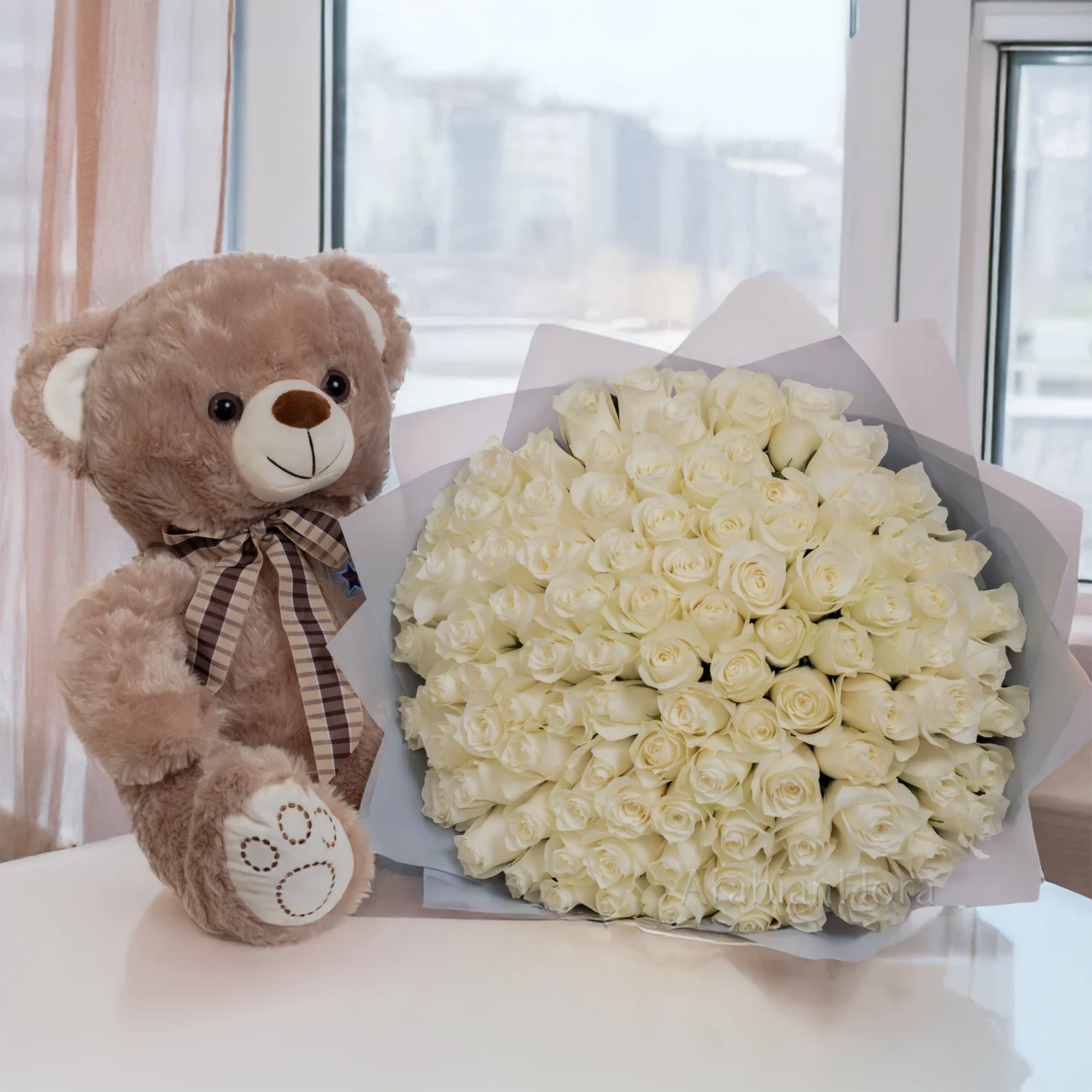 Bouquet of 100 white roses with small brown teddy bear