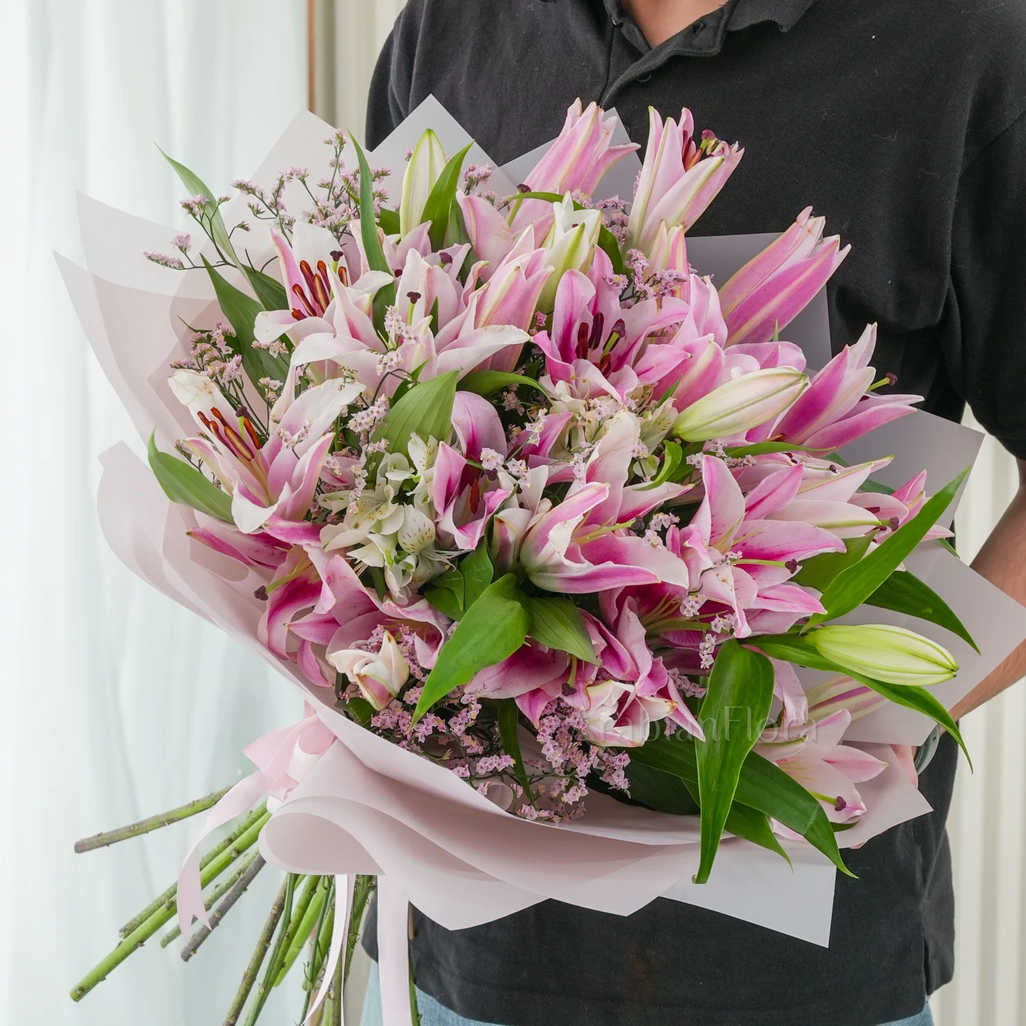 Bouquet of 10 pink lilies with green fillers beautifully wrapped in pastel pink wrapping paper.