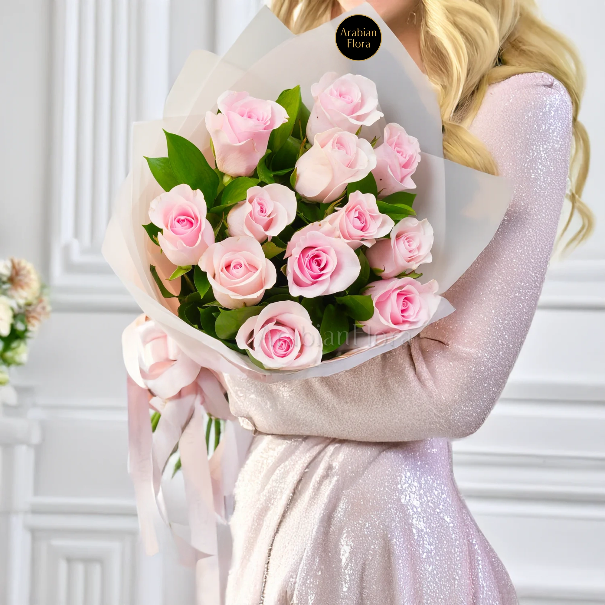 Bouquet of 12 pink roses in paper packing hand-tied with pink ribbons.
