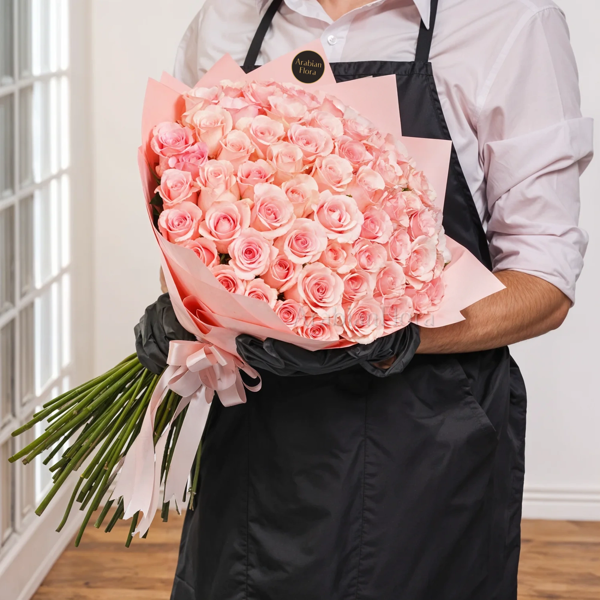Bouquet of 40 pink roses in paper packing hand-tied with pink ribbons.