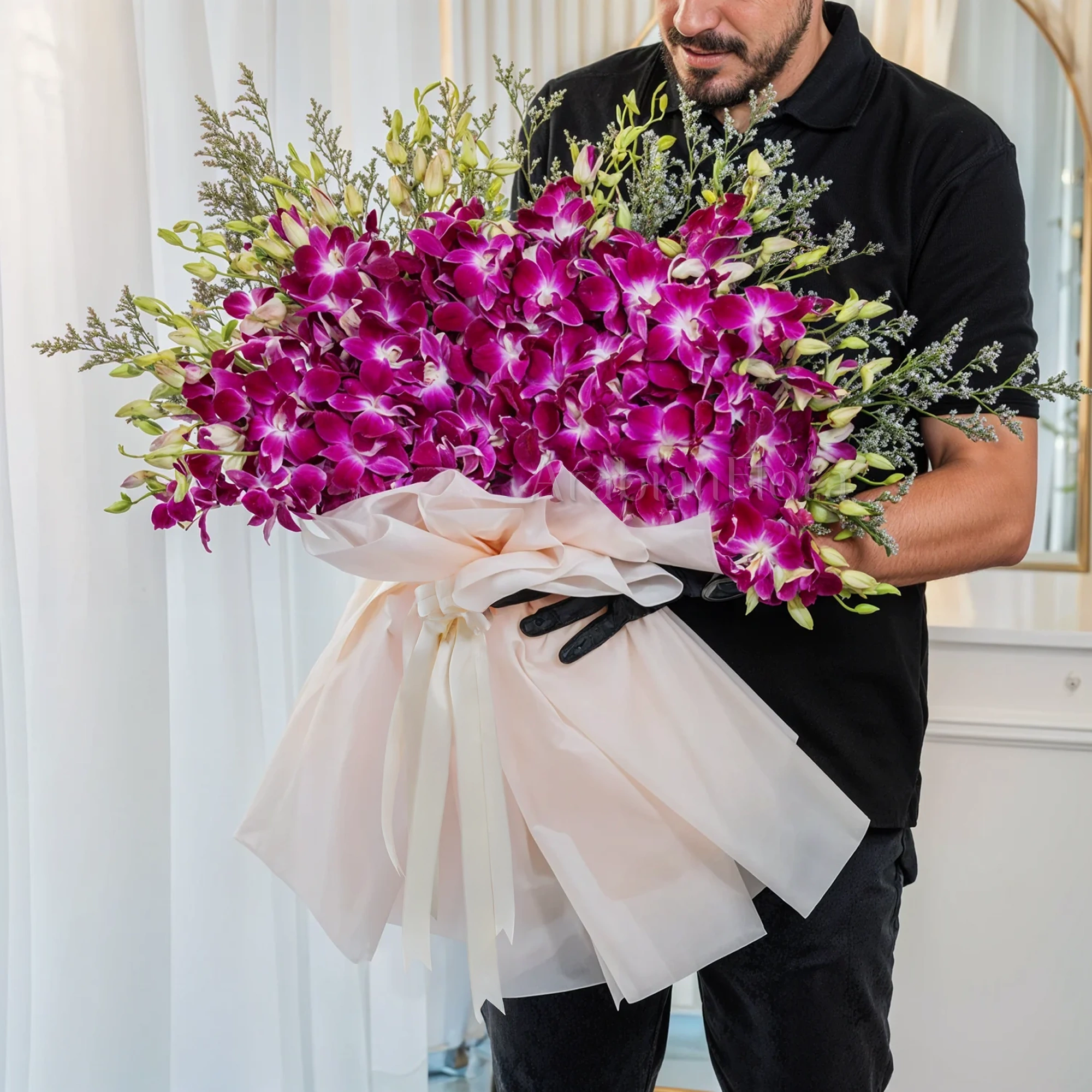 Bouquet of 40 purple orchids in paper packing tied with ribbons.