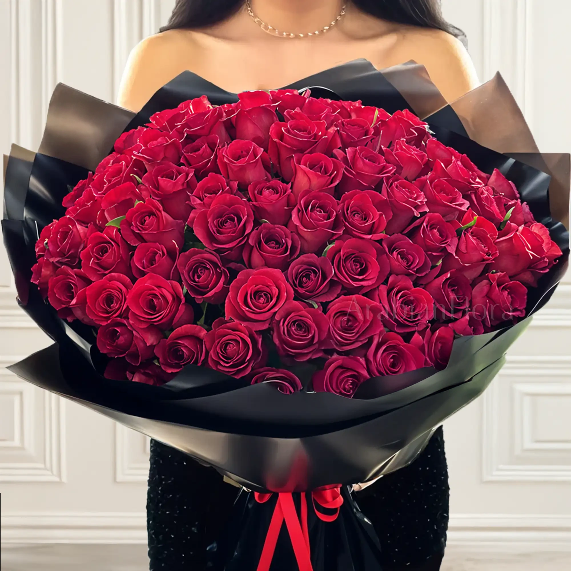 Bouquet of 100 stems of red roses with fillers in black wrapping
