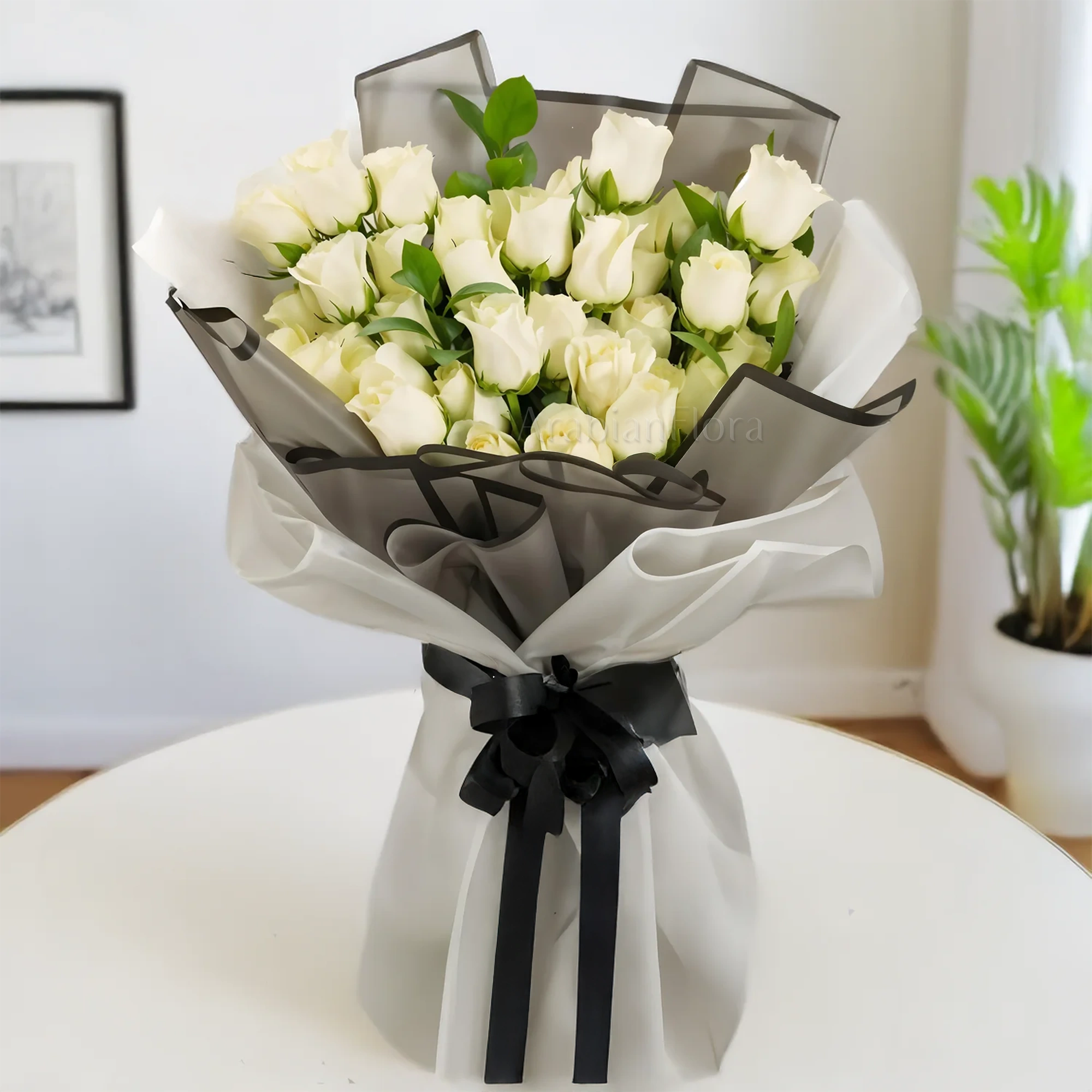 Bouquet of 30 white roses and greens nicely arranged in grey and white wrapping with black ribbons.