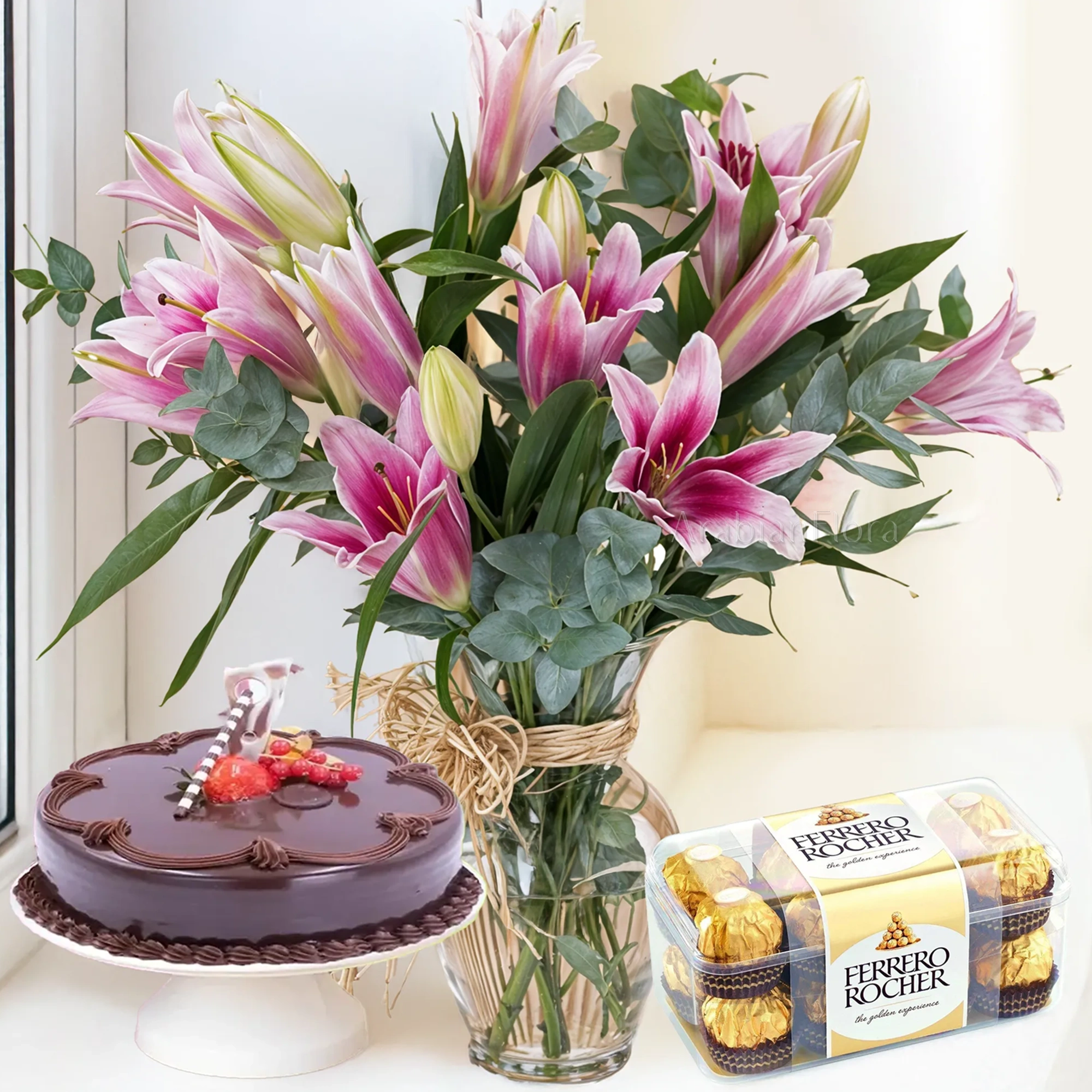 5 pink lilies with fillers in a glass vase, 1 Kg chocolate Cake and 16 pcs Ferrero Rocher Chocolate