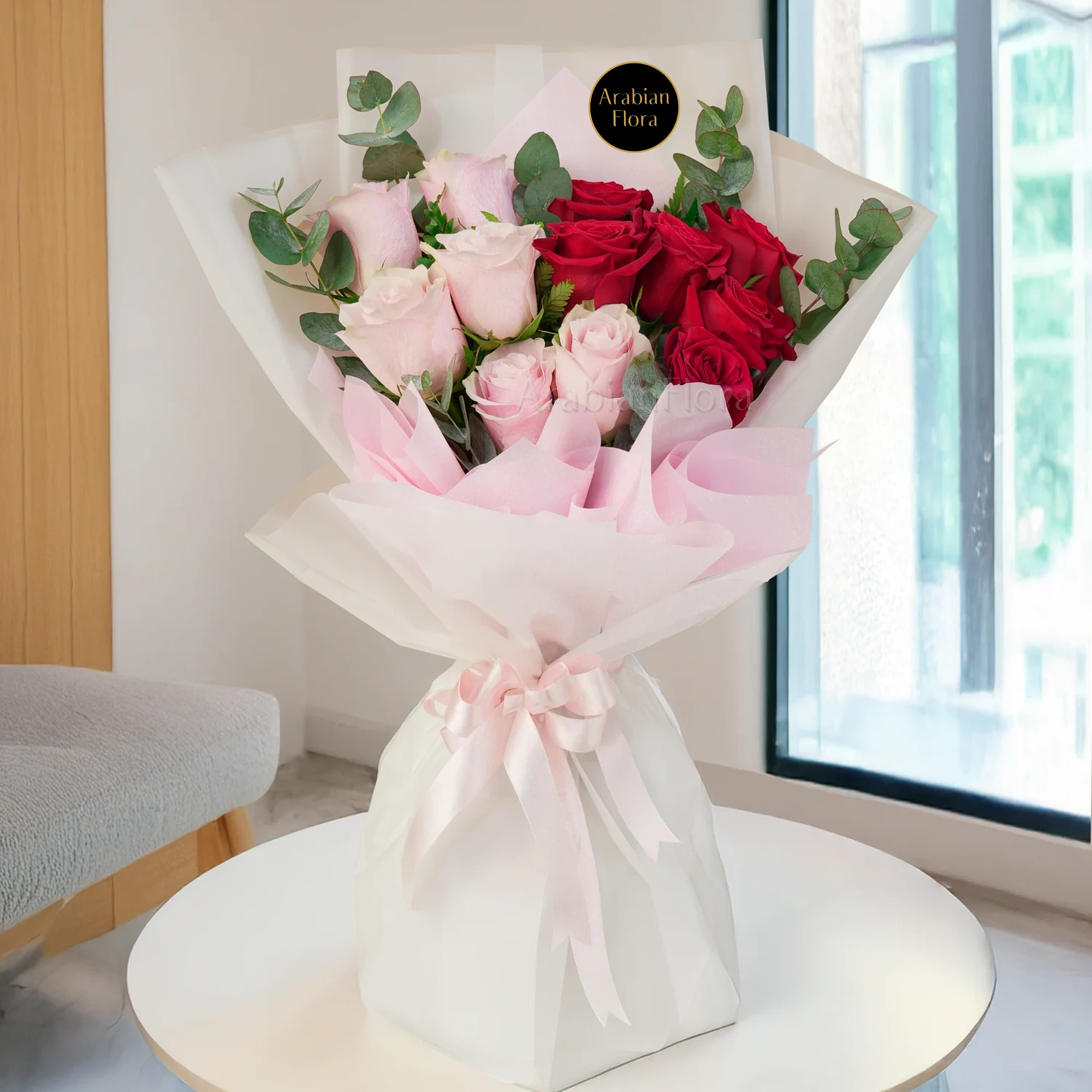 Bouquet of 6 red & 6 pink roses with green fillers in paper packing tied with pink ribbons.