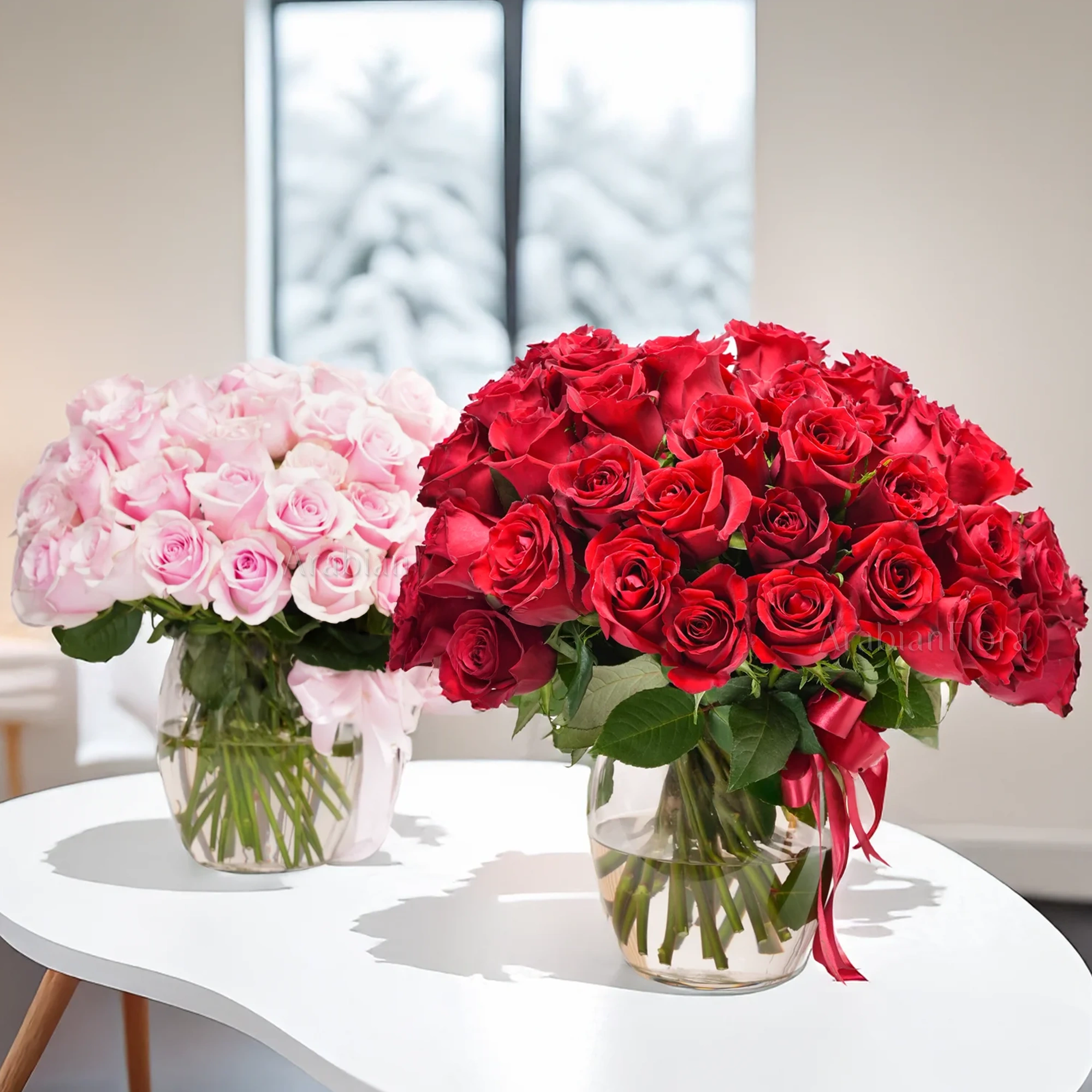 Separate vase arrangements of 50 red roses with green fillers and 50 pink roses with green fillers.