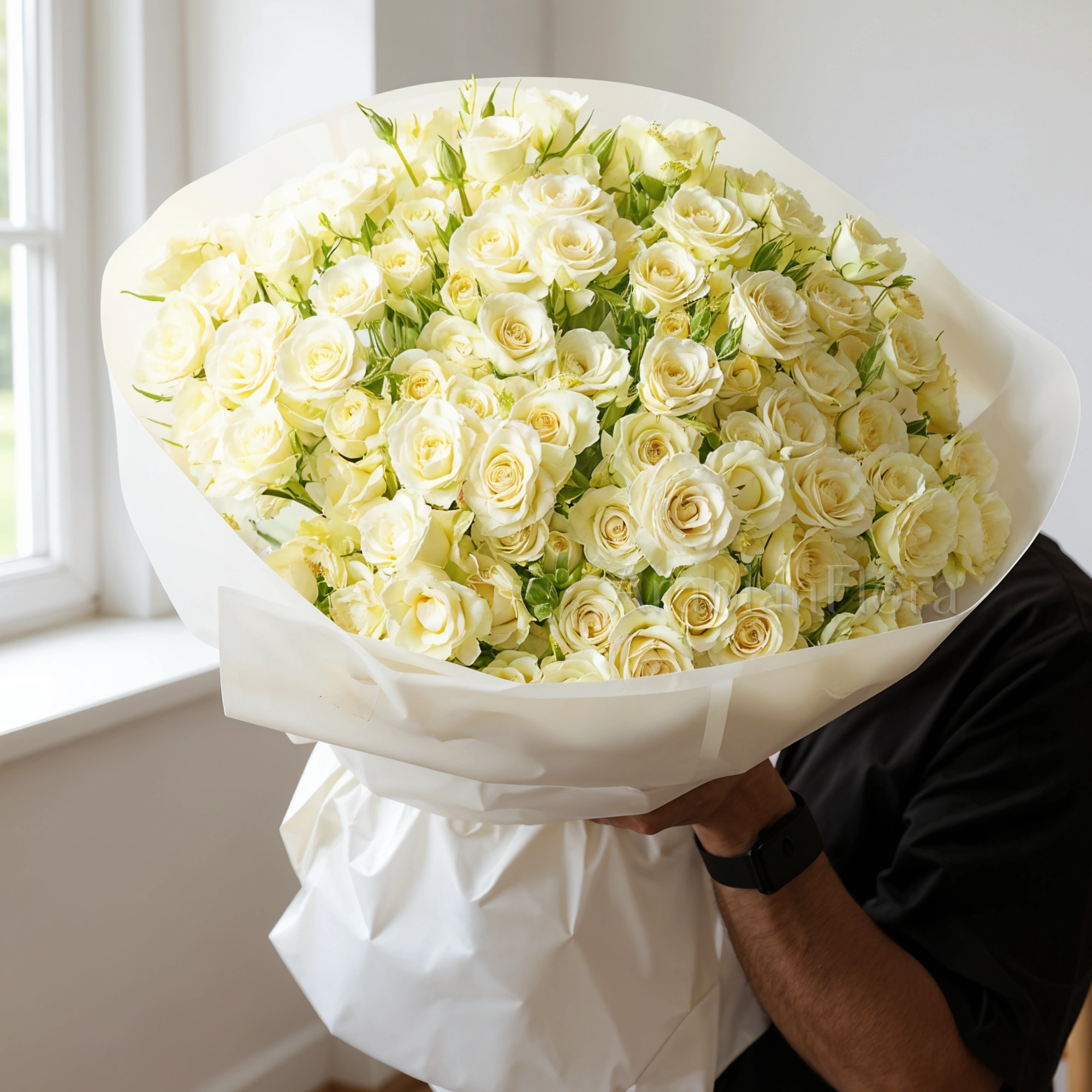 Bouquet of 40 White spray Roses with green fillers in white wrapping paper tied with ribbon.