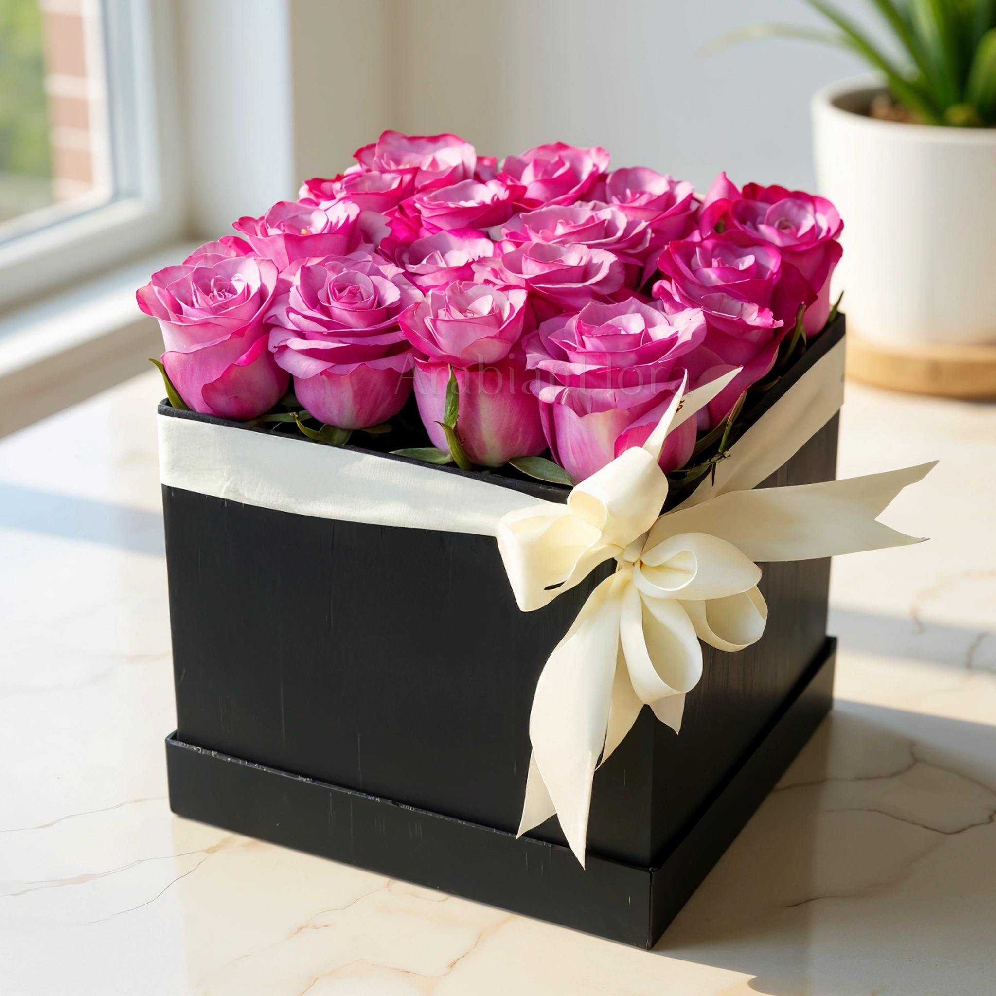 16 stems of Purple roses with fillers in a square black box with a White ribbon