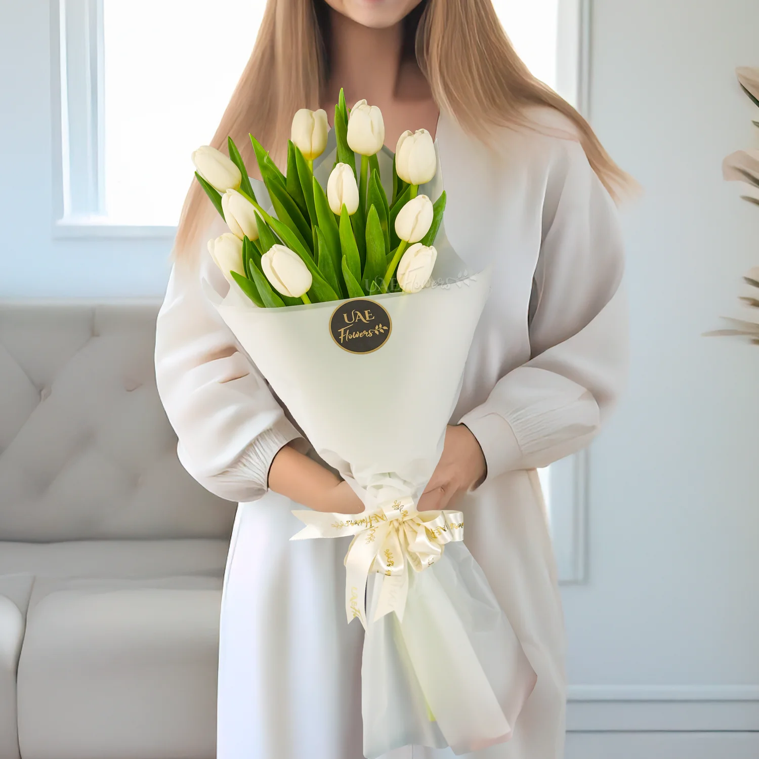 Bouquet of 10 white tulips in white paper packing tied with white ribbons.