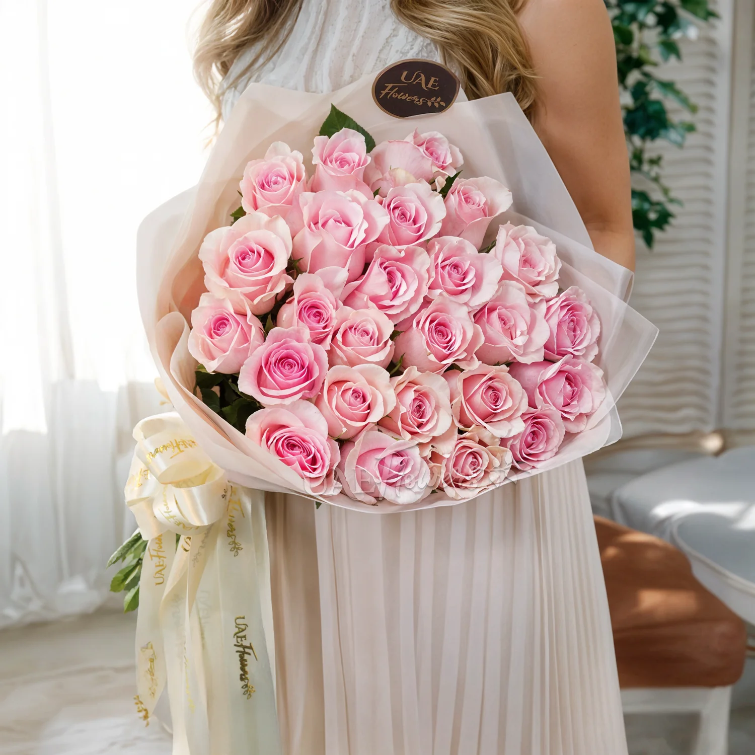 Bouquet of 20 pink roses in paper packing hand-tied with pink ribbons.