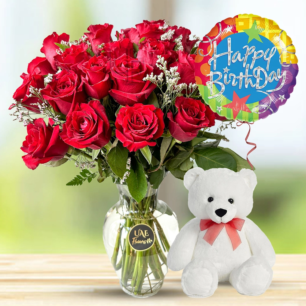 12 Red roses with fillers in a glass vase and 6 Inches teddy bear with Happy birthday foil balloon