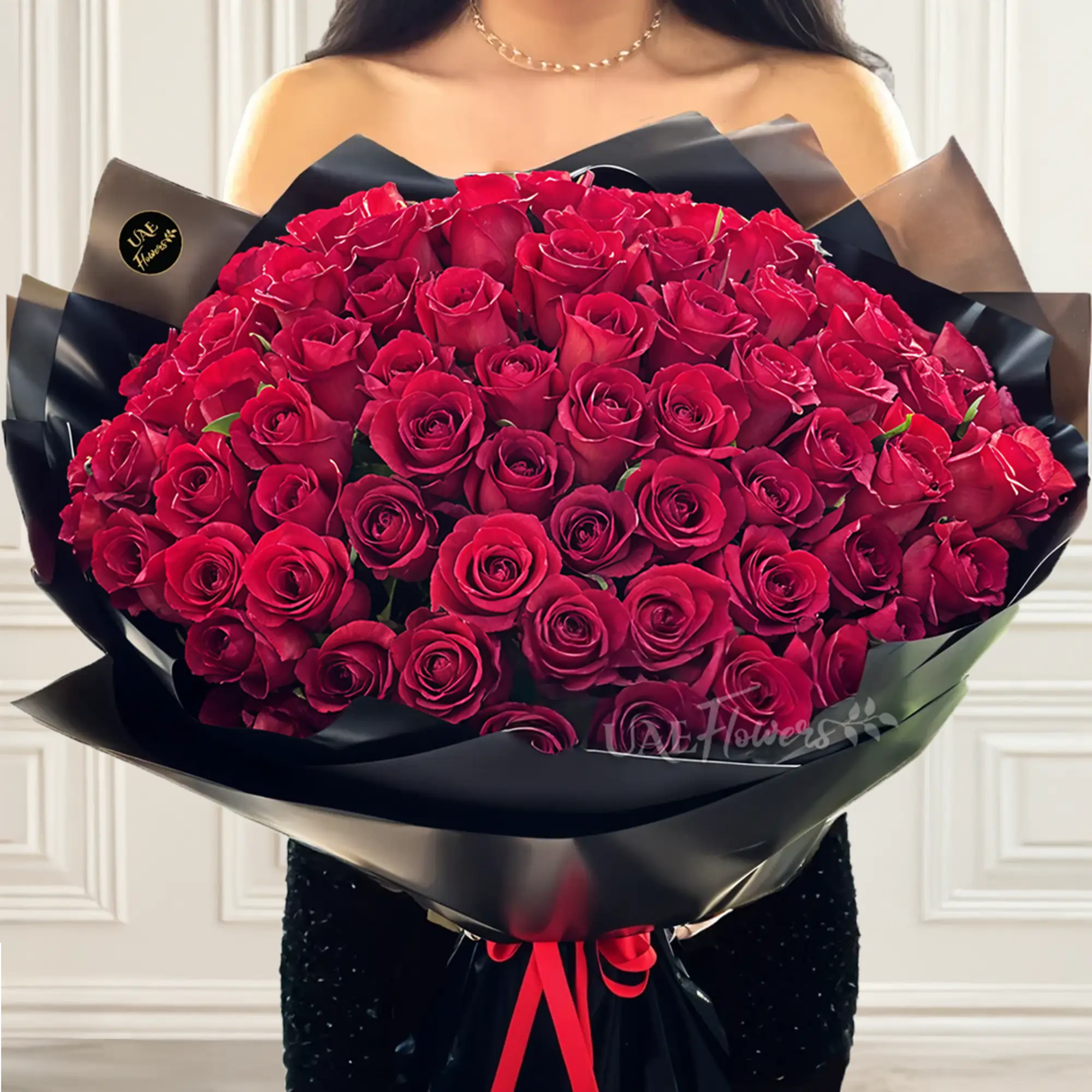 Bouquet of 100 stems of red roses with fillers in black wrapping