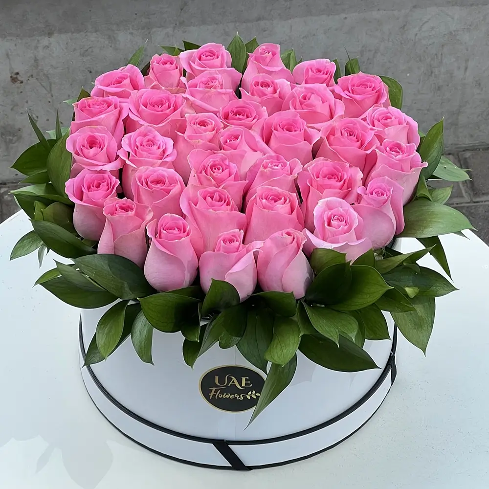 30 stems of pink roses with fillers in a white round box.
