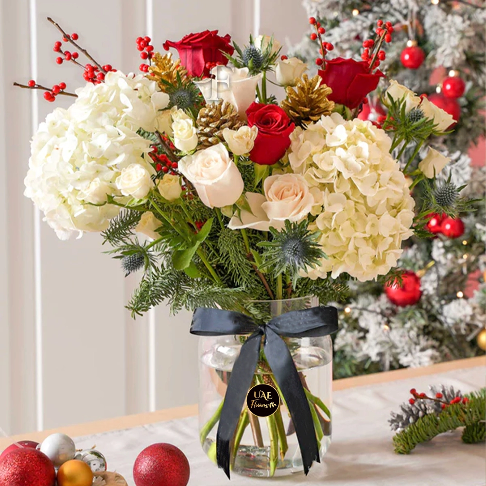 2 stems of white hydrangeas, 10 stems of red and white roses, 5 stems of white spray roses, golden pinecone and winter berries with green fillers in a glass vase with black ribbon.