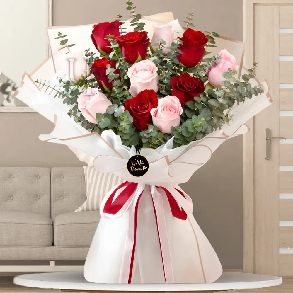 12 stems of red and pink roses with lots of eucalyptus leaves