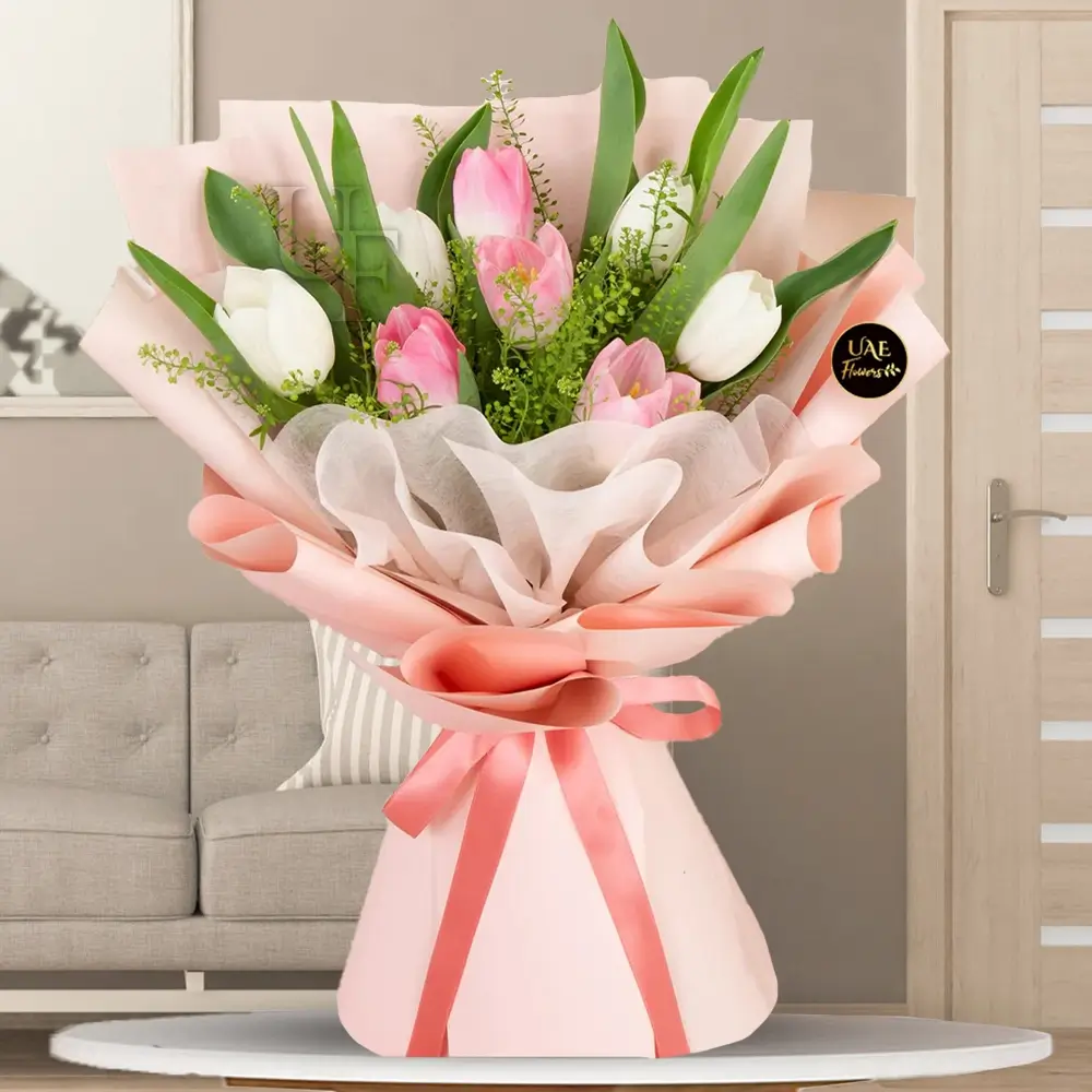 Bouquet of 10 stems of white and pink tulips with fillers beautifully wrapped in a paper packing with ribbon.