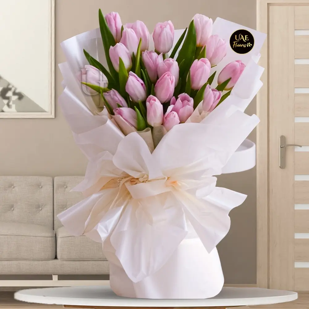Bouquet of 20 stems of pink tulips with fillers beautifully wrapped in a paper packing with ribbons