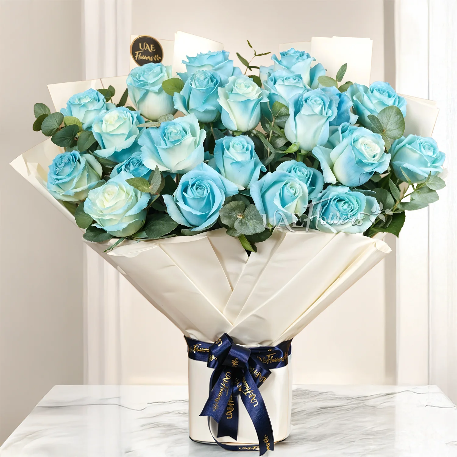 Bouquet of 25 blue sprayed roses with green fillers tied with ribbons.