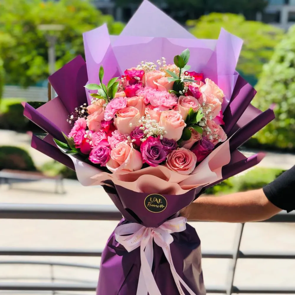 Bouquet of 9 light Pink Roses, 6 Purple Roses & 3 light Pink Carnations with fillers in a nice wrapping