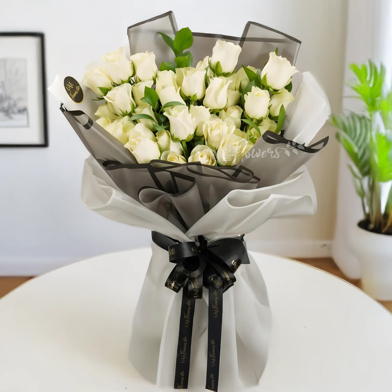 Bouquet of 30 white roses and greens nicely arranged in grey and white wrapping with black ribbons.