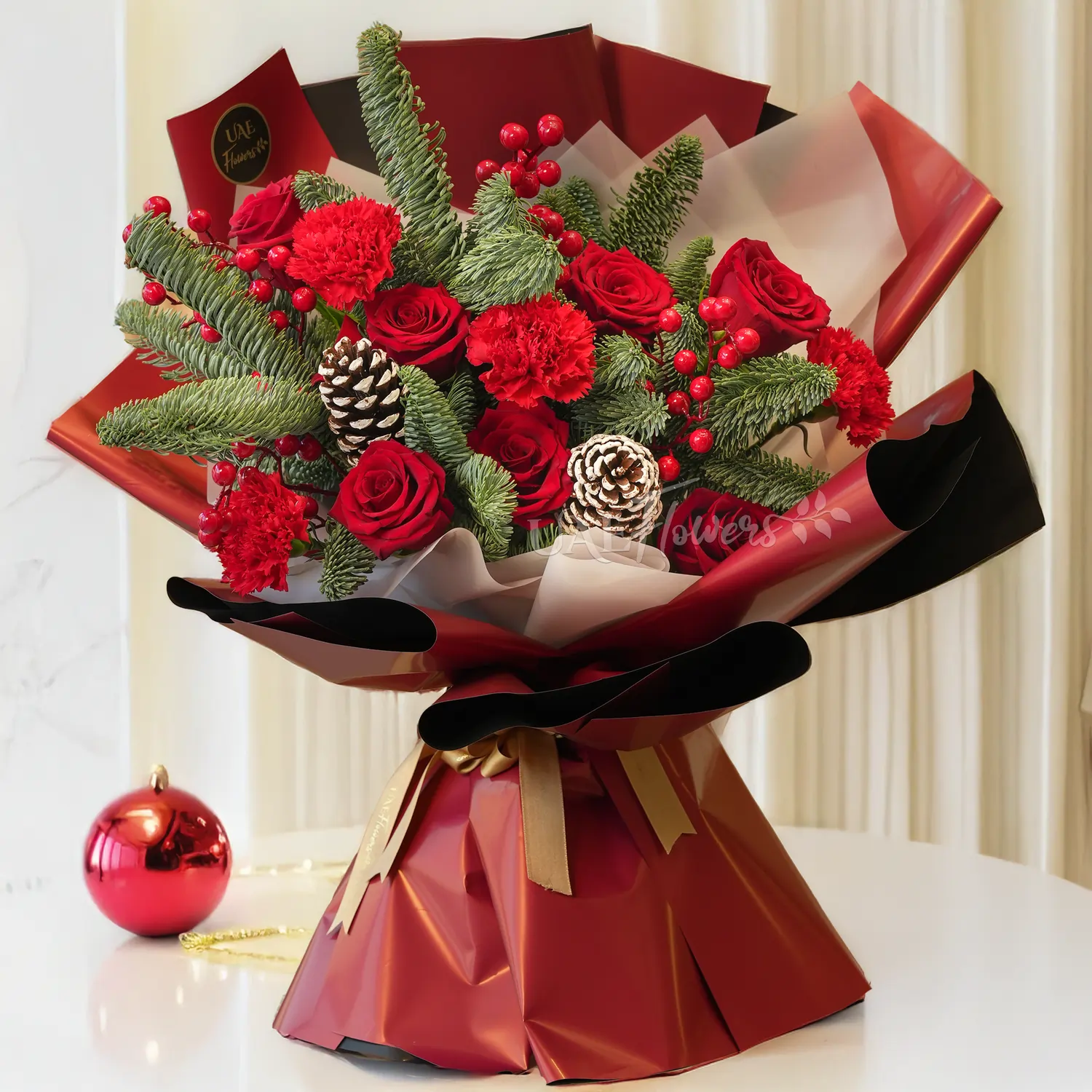 Bouquet of 7 red roses, 4 red carnations with pinecones, hypericums and pine leaf.