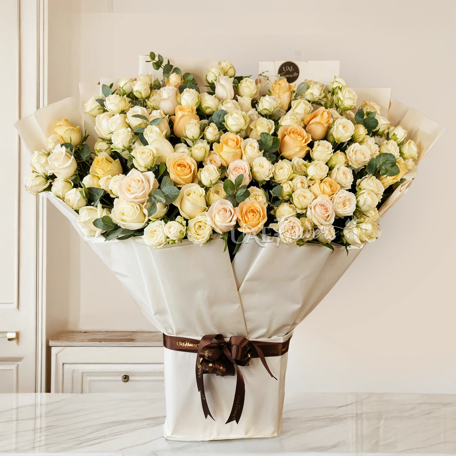 Bouquet of 20 White Spray Roses, 20 White Roses and 20 Peach Roses with green fillers tied with ribbons.