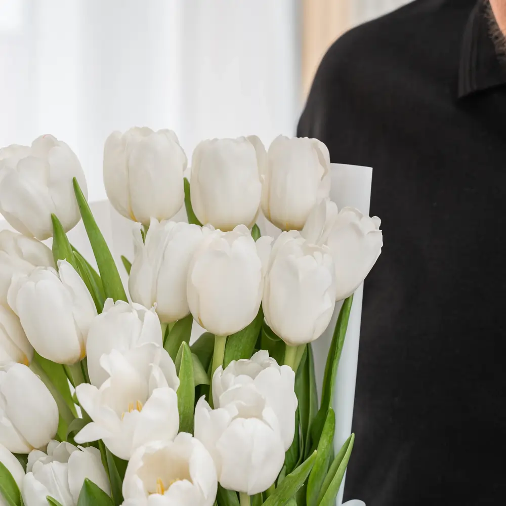 Bouquet of 20 white tulips in premium white wrapping tied with satin ribbon.