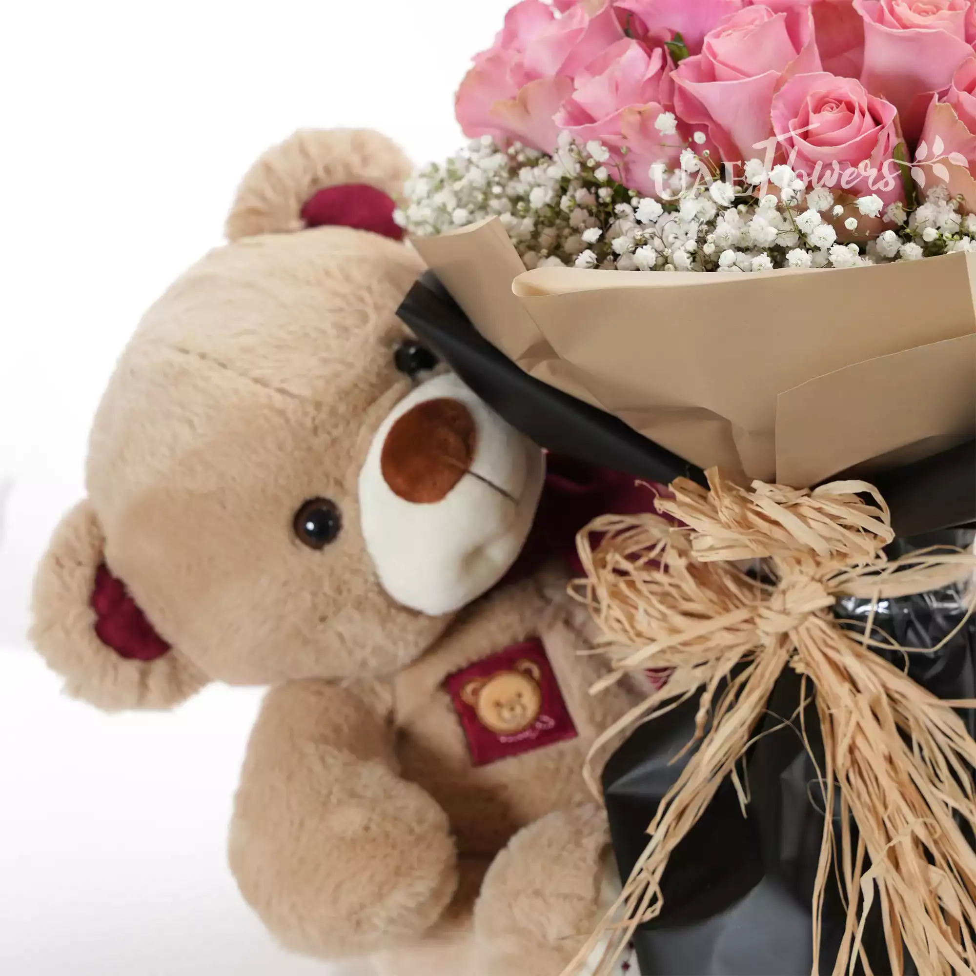 Bouquet of 20 pink roses with baby's breath fillers in paper packing with medium size brown teddy bear