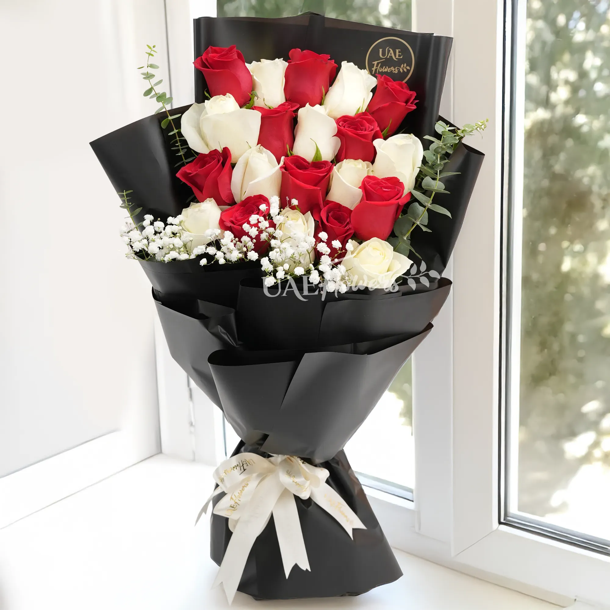 Bouquet of 20 red and white roses with baby's breath fillers in black wrapping paper tied with white ribbons.