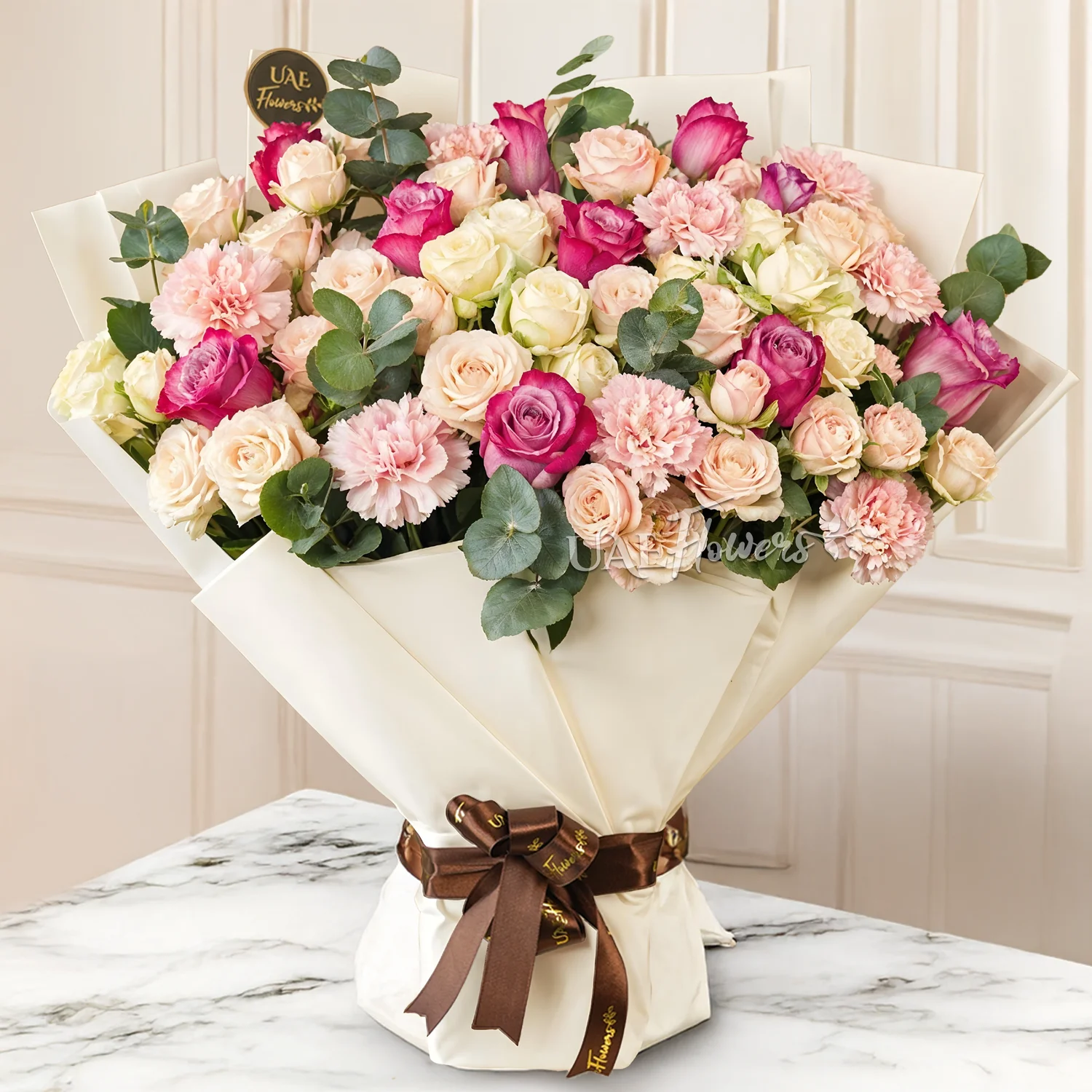 Bouquet of 12 Purple roses, 6 pink spray roses, 6 white spray roses and 6 pink carnations with green fillers tied with ribbons.