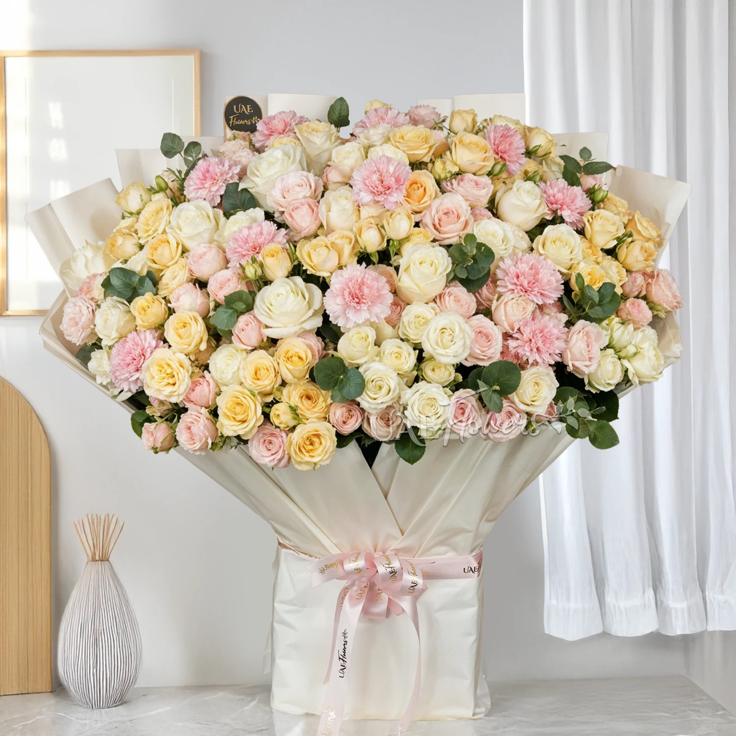 Bouquet of 30 peach, pink & white spray roses, 10 pink carnations and 10 white roses with green fillers and tied with ribbons.