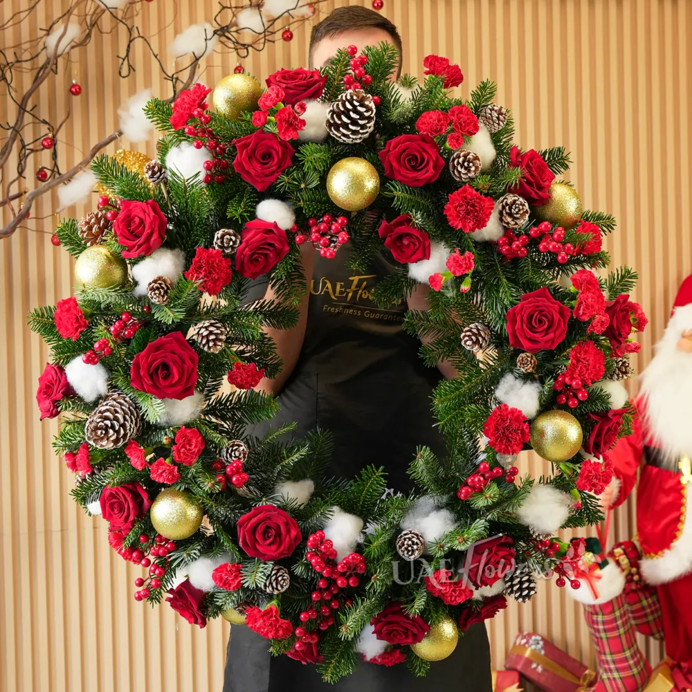 A Christmas wreath of 20 red roses, 25 red carnations, pine cones, pine leaves, decorative Christmas items and hypericum