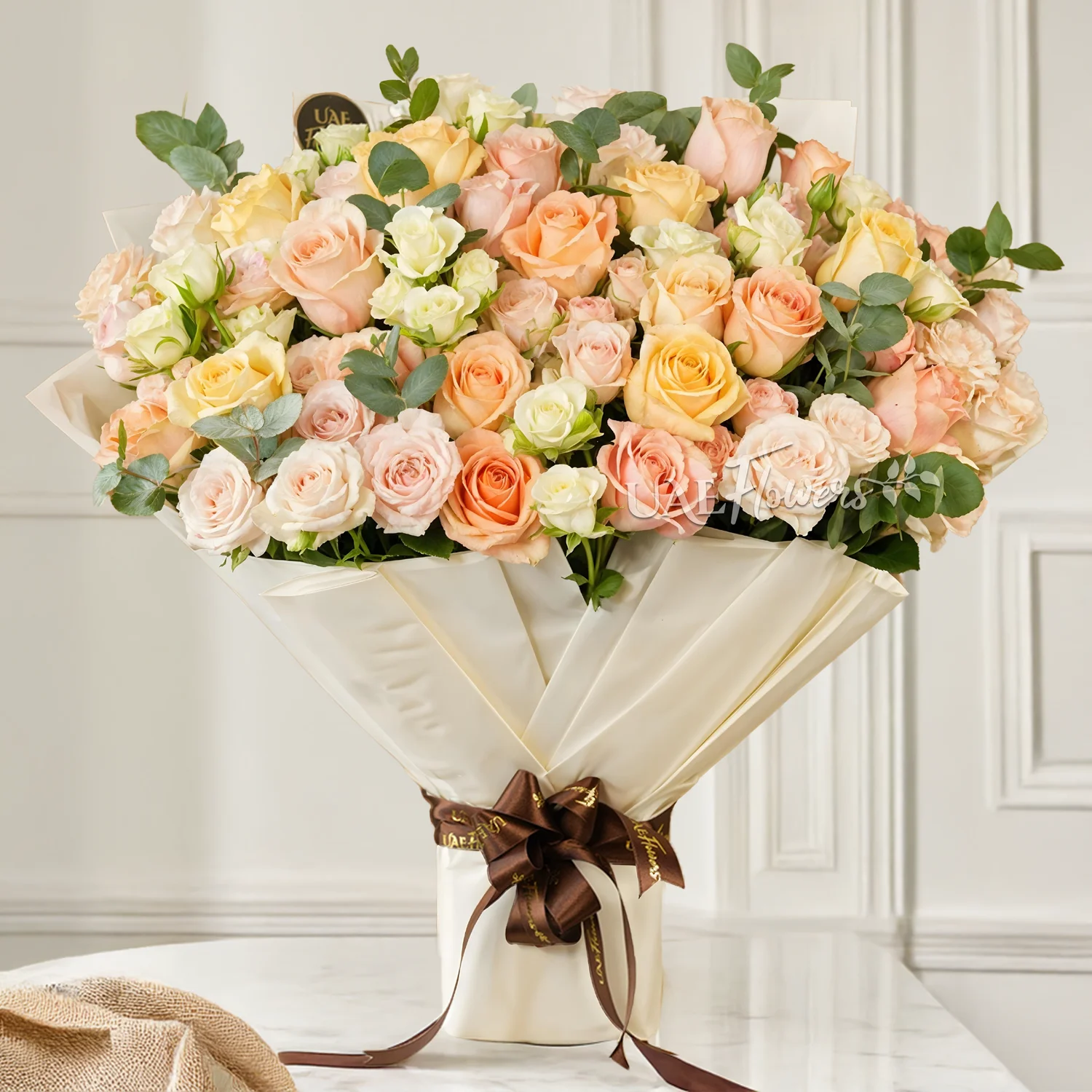 Bouquet of 5 white spray roses, 5 pink spray roses and 20 mixed pastel coloured roses with green fillers tied with ribbons.