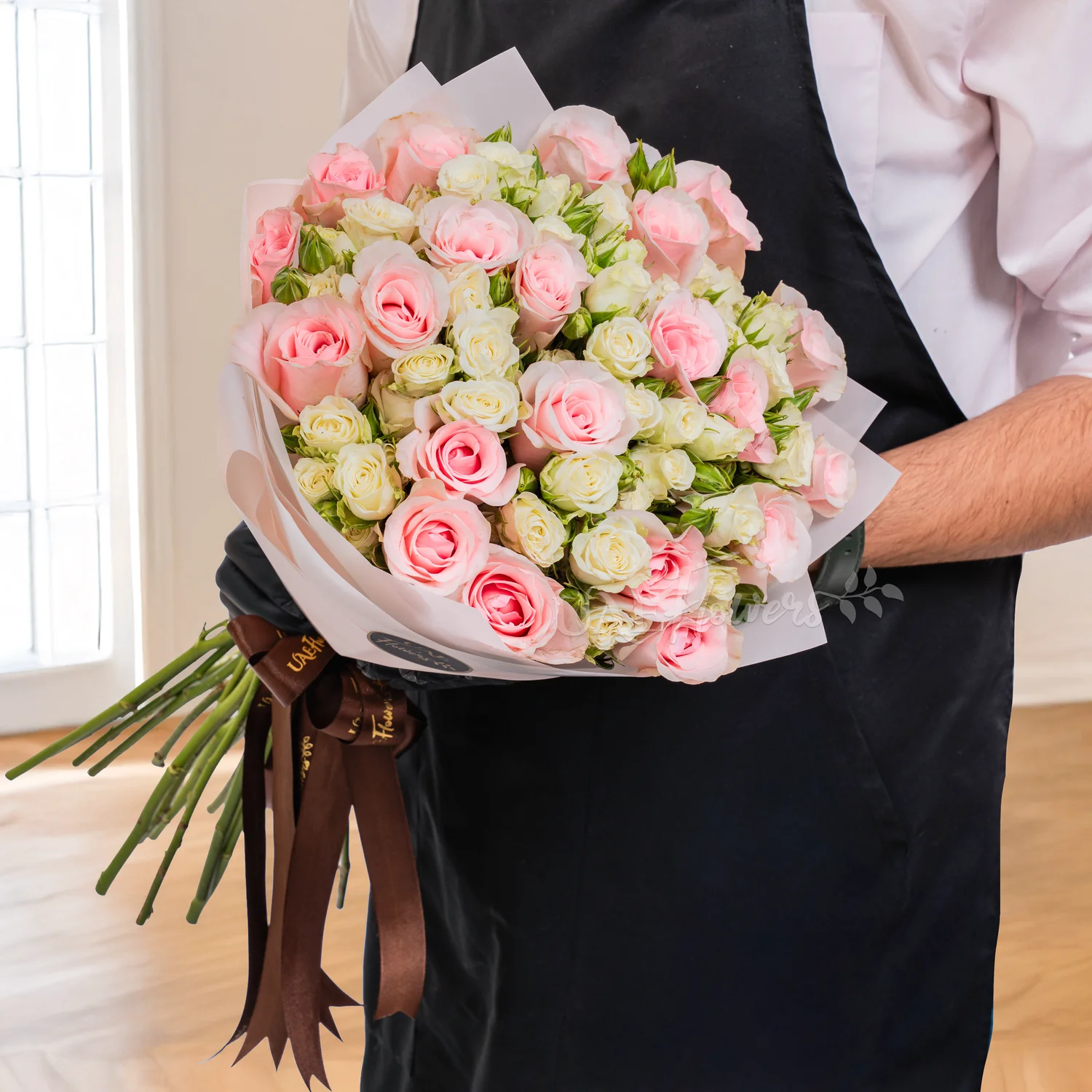 20 pink roses and 10 white spray roses in paper packing hand-tied with ribbons.