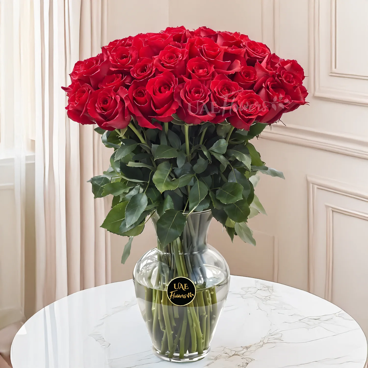 30 long stems of red roses with fillers in a glass vase.