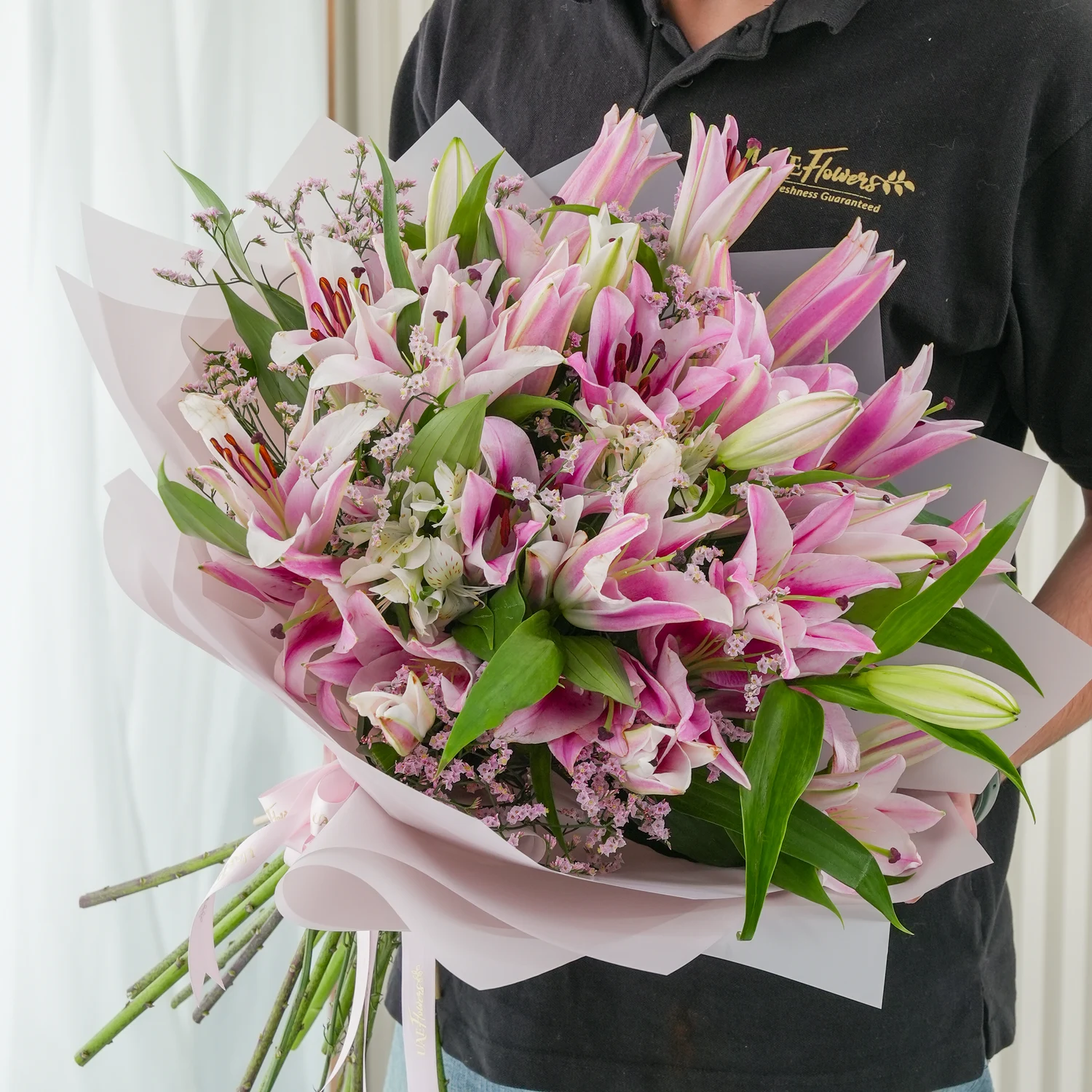 Bouquet of 10 pink lilies with green fillers beautifully wrapped in pastel pink wrapping paper.
