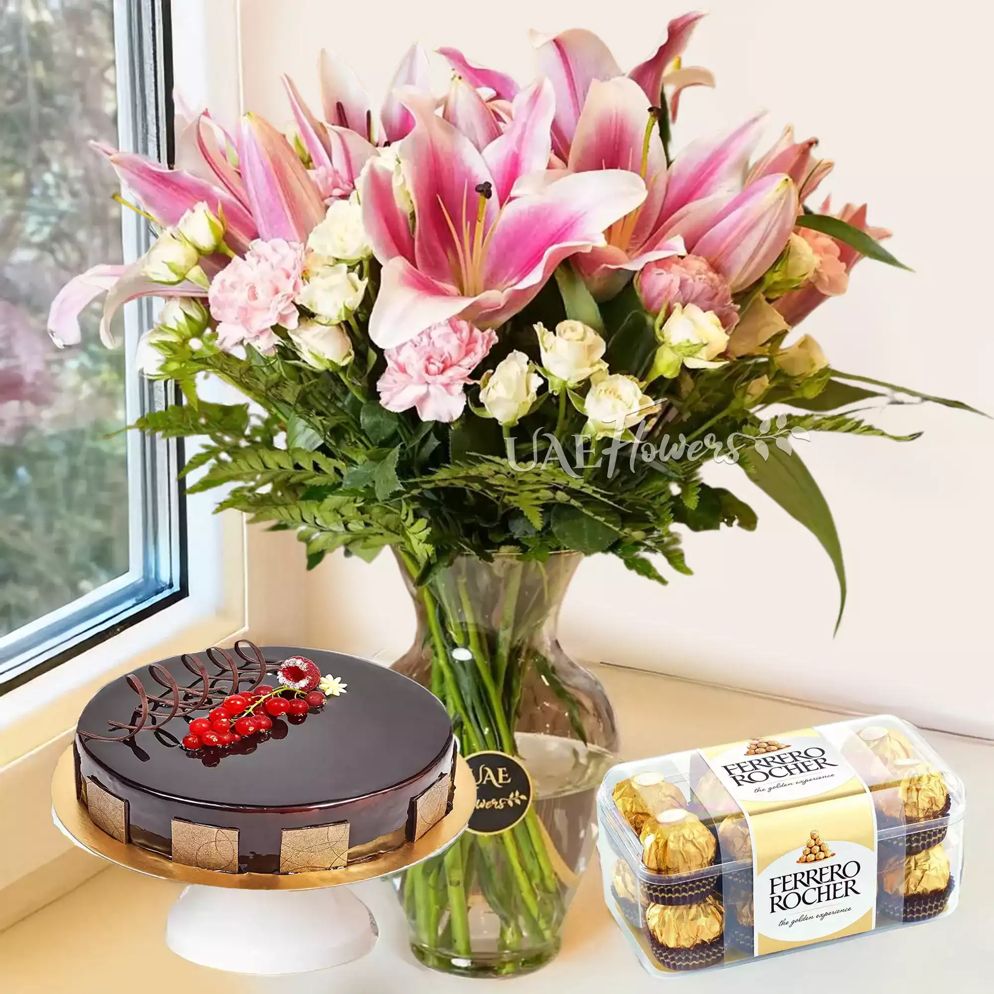 pink lilies, pink carnations, white spray rose, chocolate cake, 16 pcs of ferrero rocher chocolate.