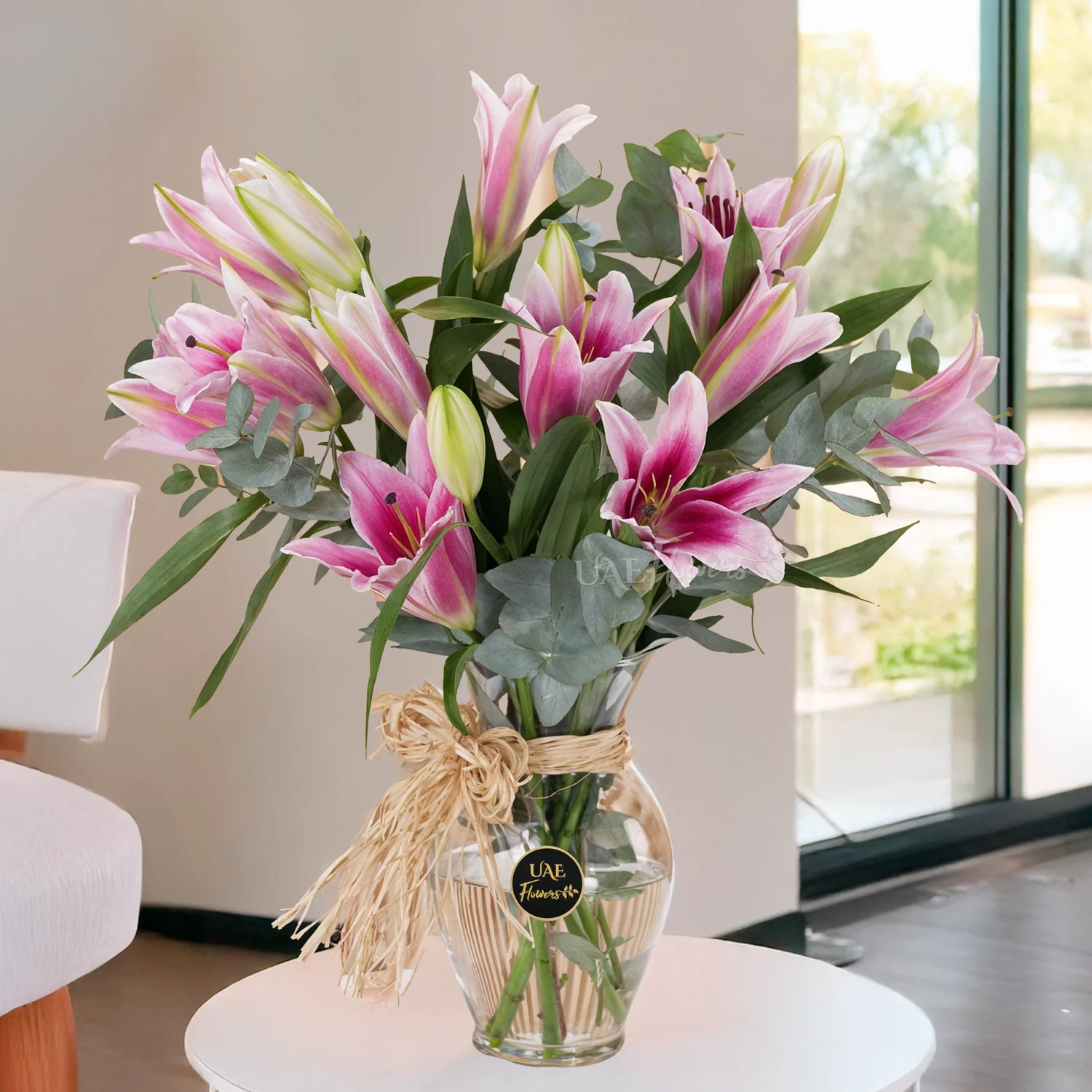 5 pink lilies with green fillers in a glass vase