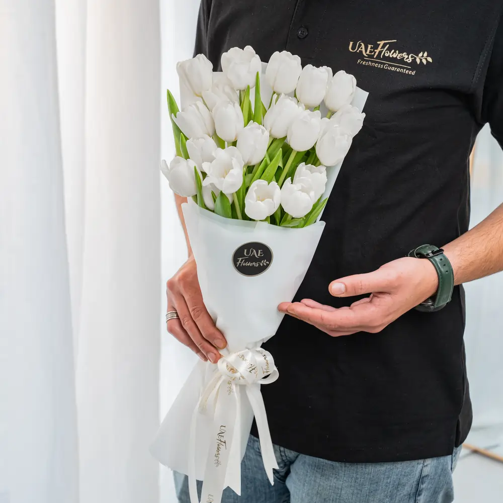 Bouquet of 20 white tulips in premium white wrapping tied with satin ribbon.