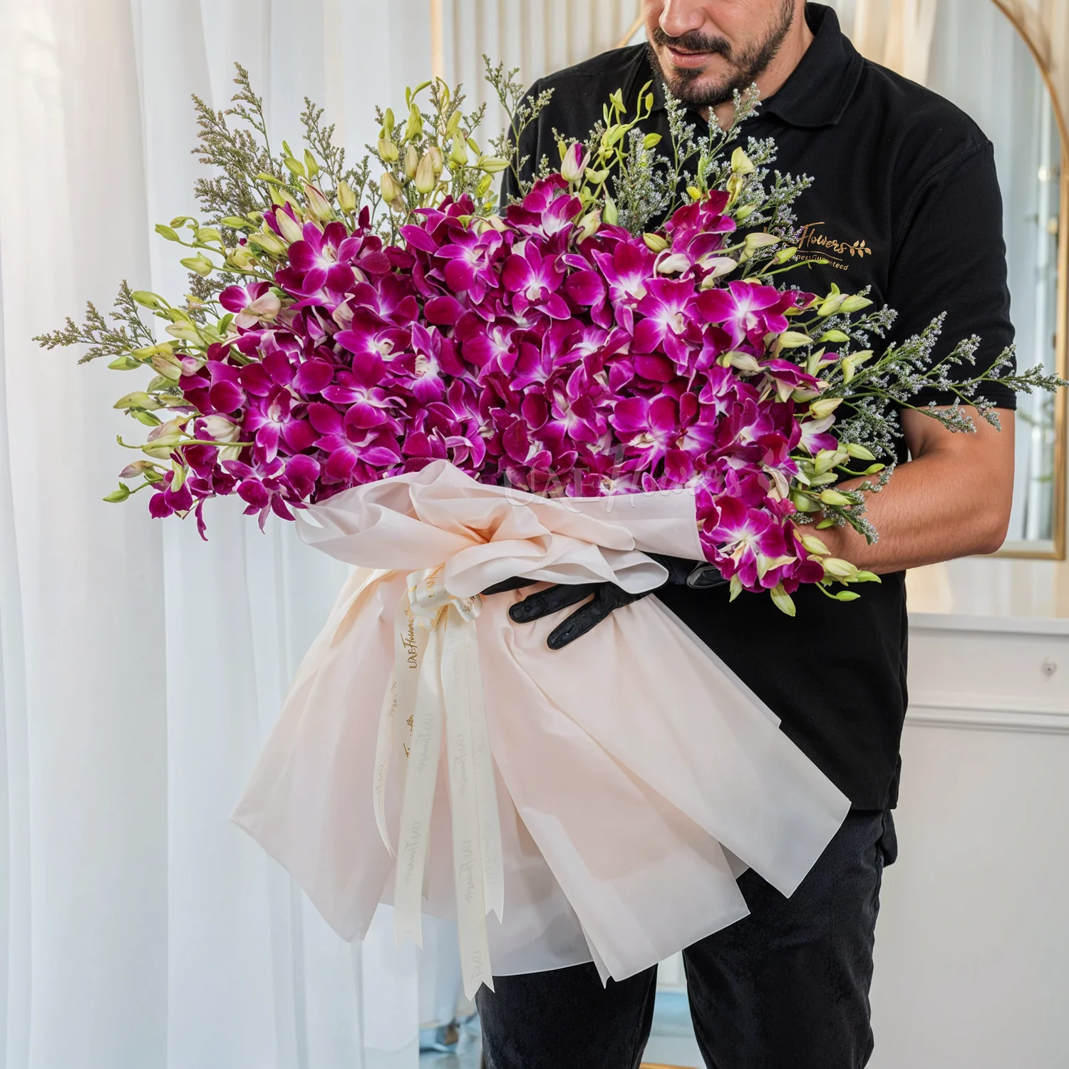Bouquet of 40 purple orchids in paper packing tied with ribbons.
