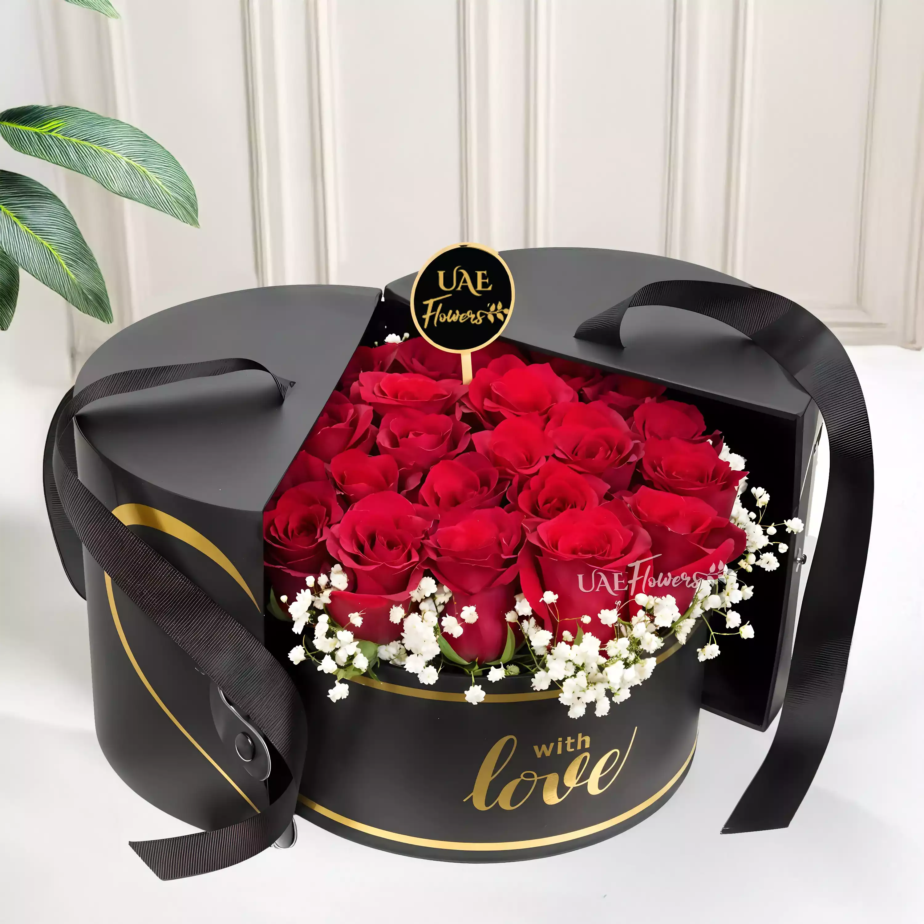 15 stems of red roses with baby's breath arranged in a black round box.