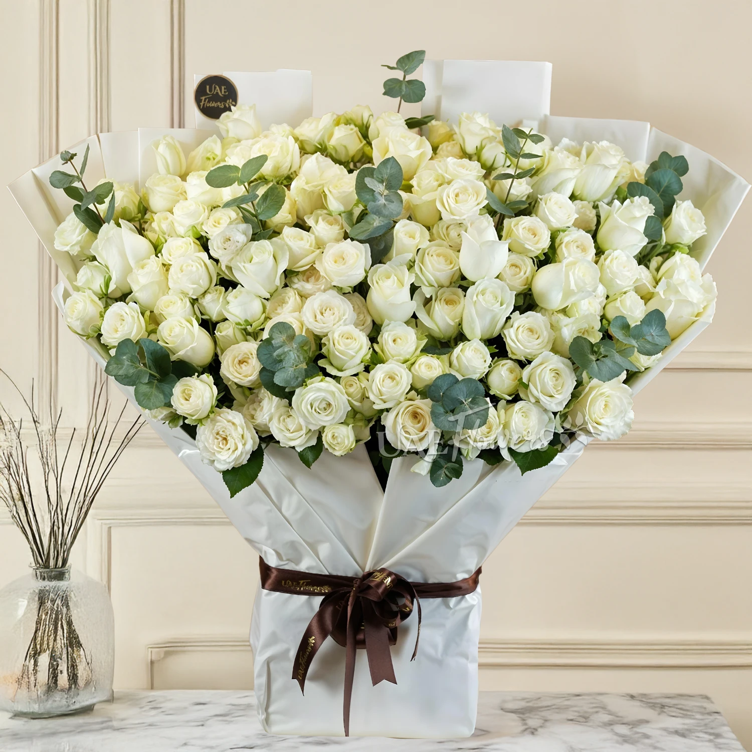 Bouquet of 20 white spray roses and 20 white roses with green fillers and tied with ribbons.